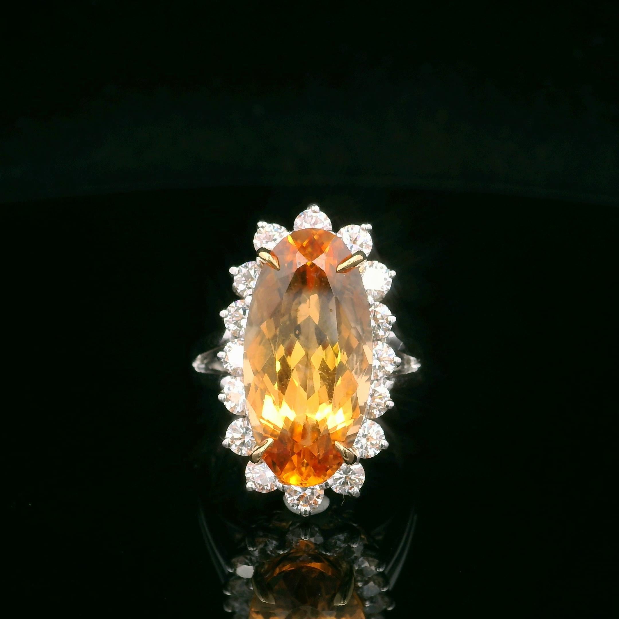 Cette bague Oscar Heyman est fabriquée en platine et en or jaune 18 carats autour d'une topaze impériale de 10,75 carats (rapport de C.C.), une couleur rare et appréciée dans la famille des topazes. La pierre centrale est entourée de 16 diamants