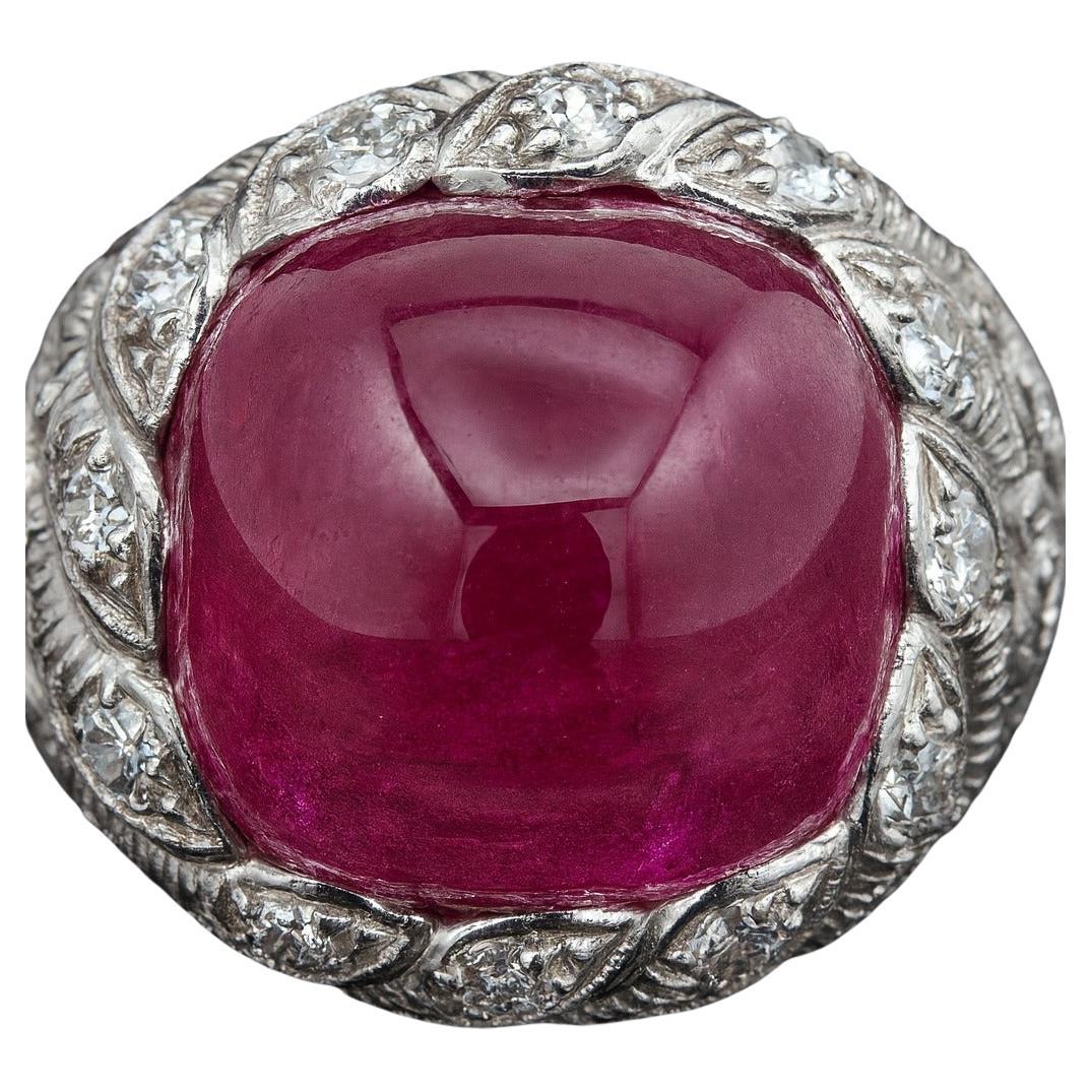 Cette spectaculaire et importante bague d'Oscar Heyman met en valeur un rubis rouge vif carré taillé en coussin pesant environ 12,96 carats, magnifiquement complété par des diamants brillants taillés en rond d'un poids total d'environ 2,23