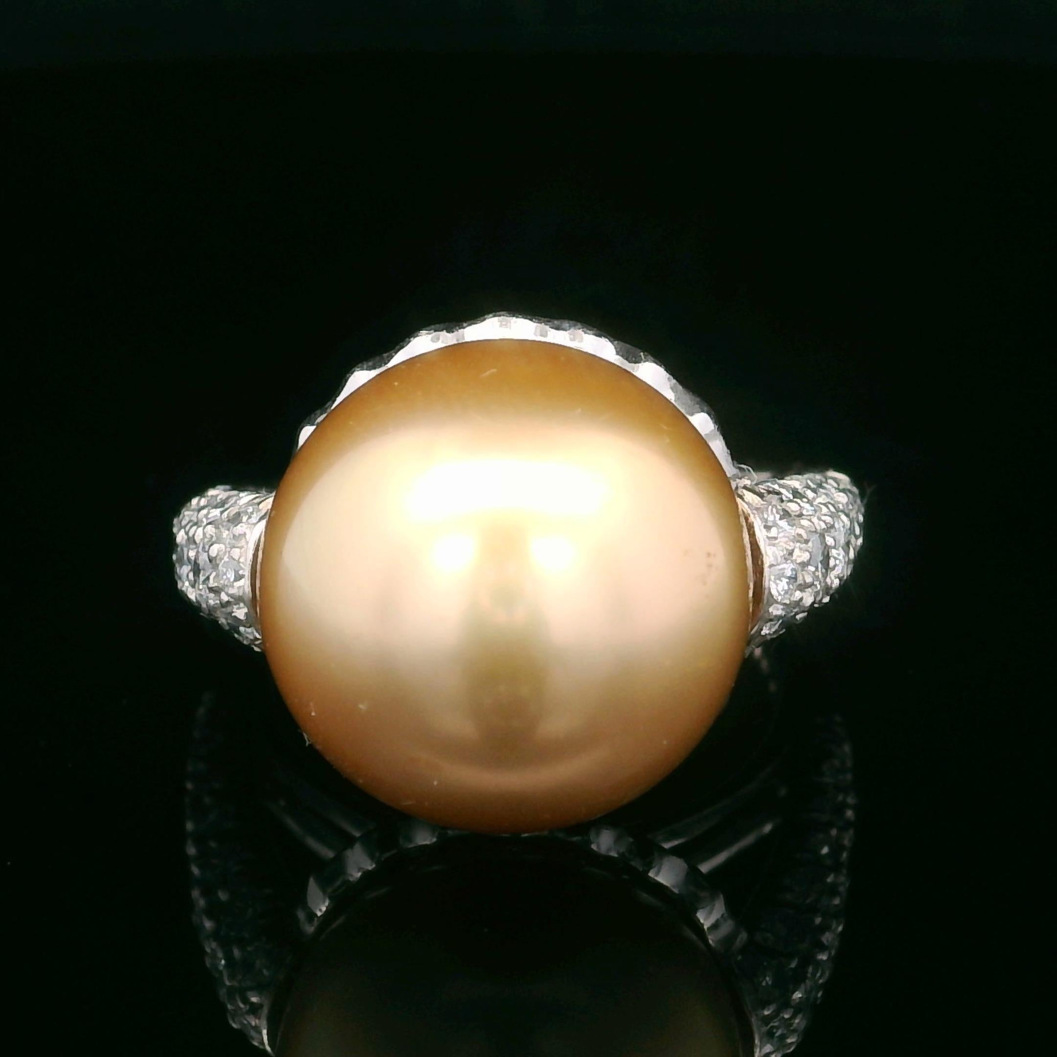 This Oscar Heyman ring is made from platinum and contains a 14mm Golden South Sea Pearl and 78 round diamonds weighing 1.78cts. The pearl is nestled in a cup of bead set pave diamonds. It is stamped with the makers mark, IRID PLAT, and serial number