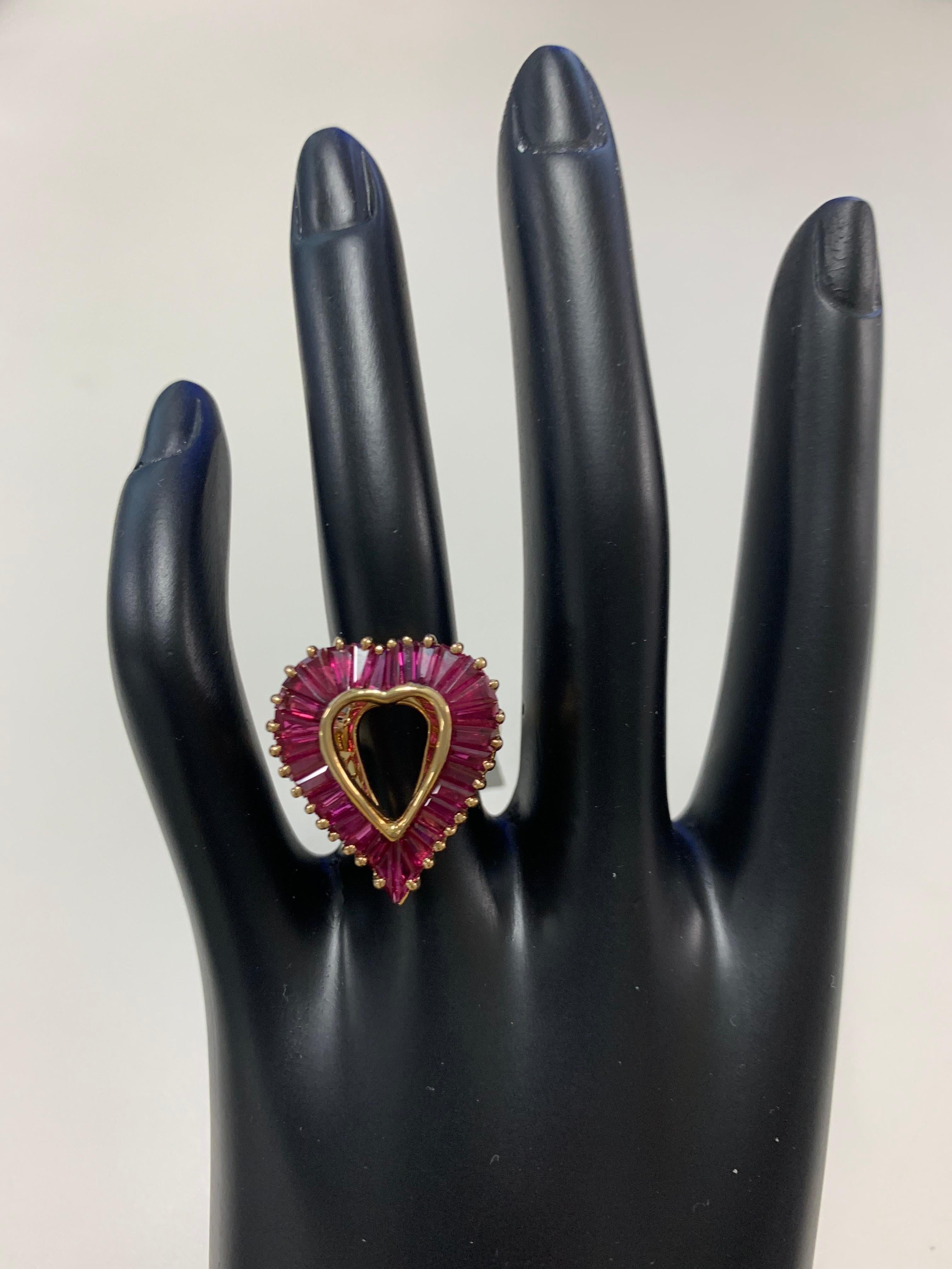 Oscar Heyman 18k yellow gold ring contains 31 baguette rubies (4.05tcw) set in the 'ballerina' style. It is stamped with the makers mark, 18K, and serial number 302795.

Size 6. Can be sized at no charge between a 5 - 7. No refunds on re-sized