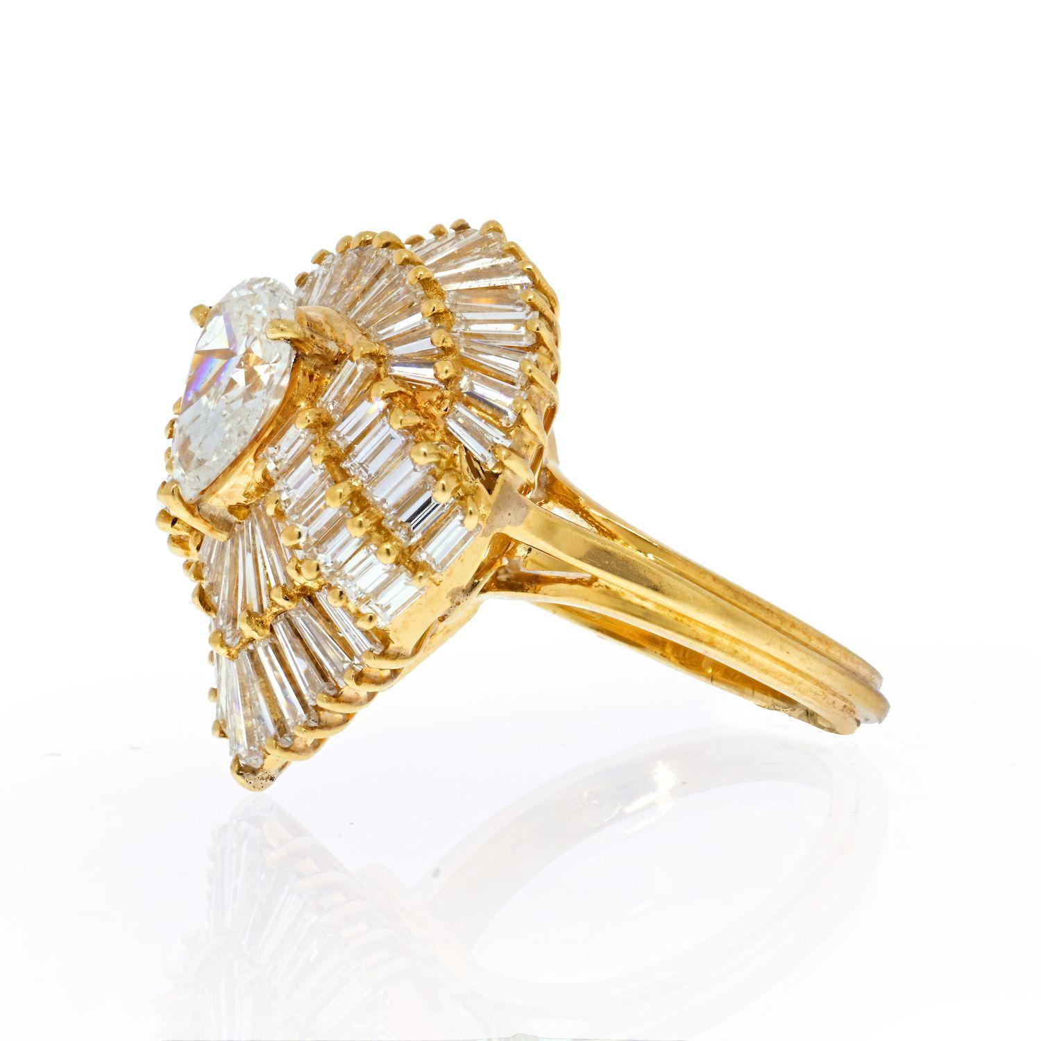 This shimmering 18k yellow gold diamond ring is crafted centering 1.27 carat Pear-Cut diamond. Surrounded by a double halo of baguette cut diamonds weighing approx. 3.50 carats, graded H-I color, and VS1-VS2 clarity. 
Top measures: 23mm x 18mm. Ring