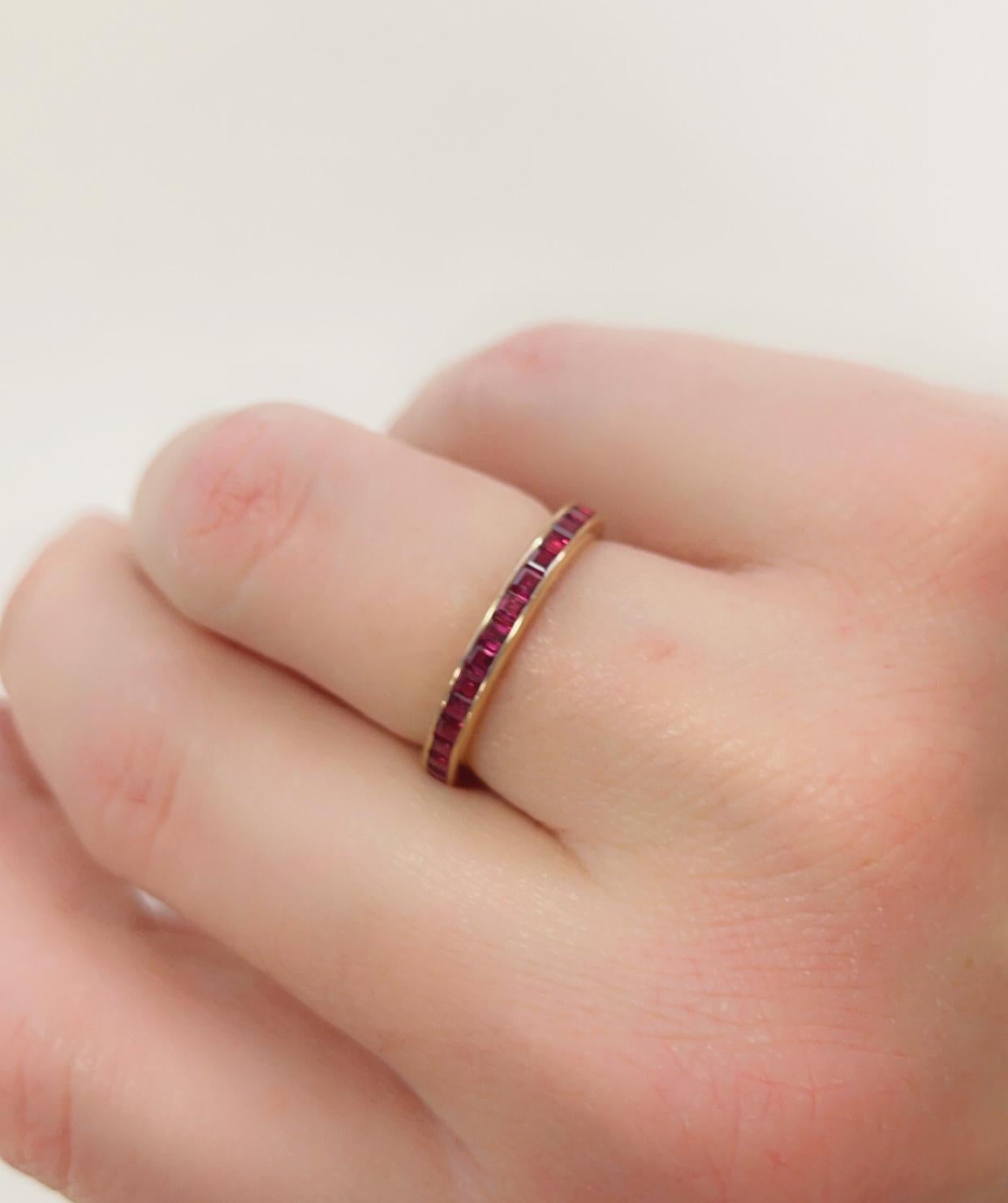 Anillo de banda calibre rubí de oro amarillo de 18 quilates de Oscar Heyman contiene 35 rubíes cuadrados con un peso de 1,48 quilates. Los rubíes se extienden alrededor de todo el anillo. El anillo mide 2,5 mm de ancho y lleva estampada la marca del