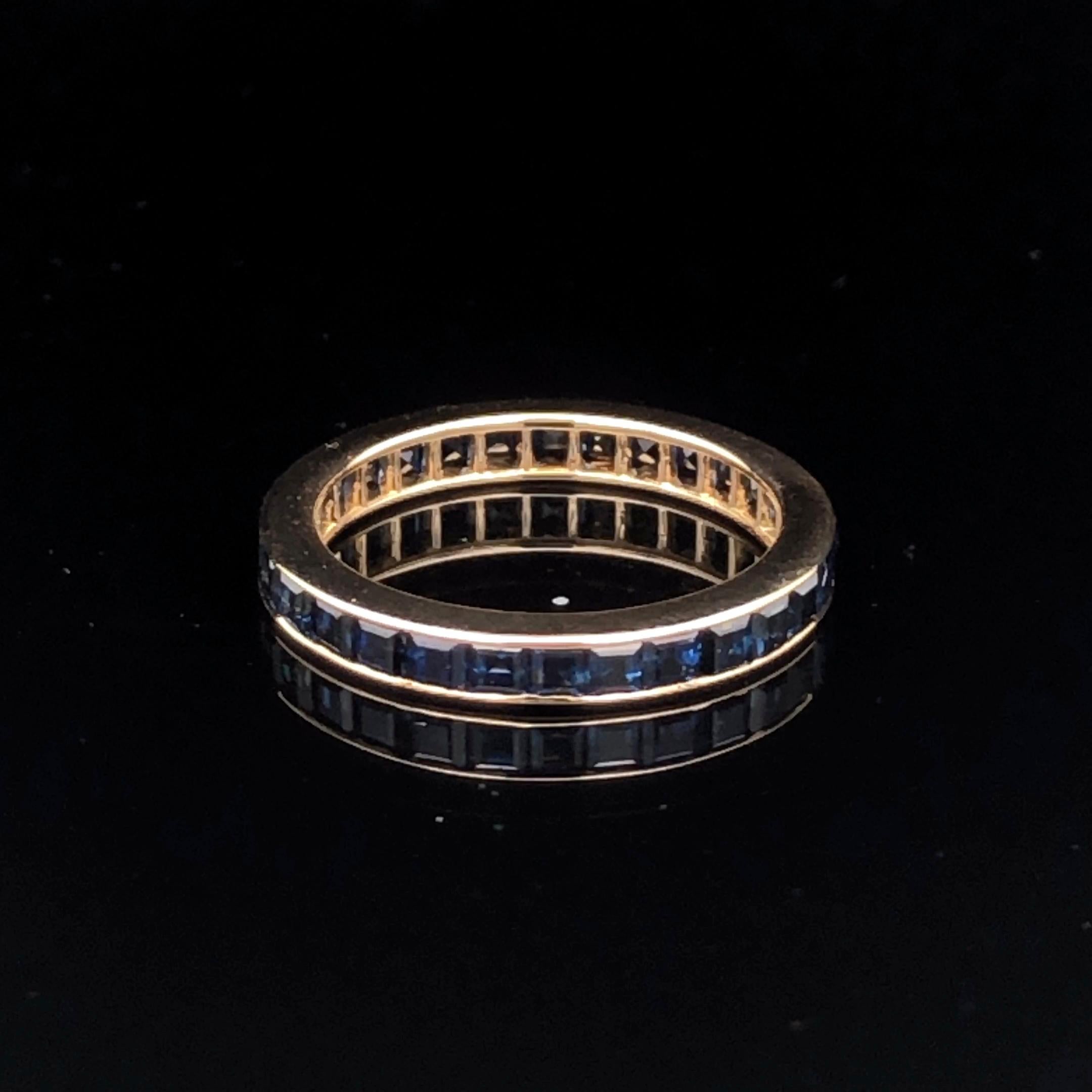 La bague en or jaune 18 carats d'Oscar Heyman contient 30 saphirs carrés pesant 2,21 cts. Les saphirs s'étendent sur tout le pourtour de l'anneau. La bague mesure 2,75 mm de large et porte la marque du fabricant, 18K, et le numéro de série J4338. Il