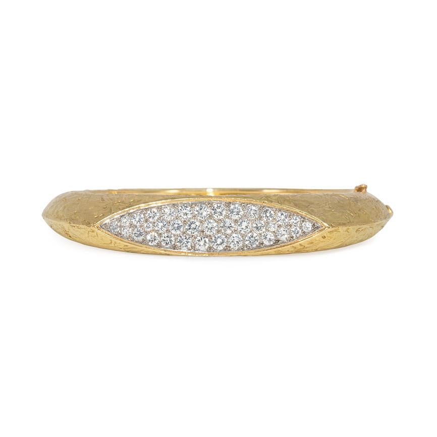 A textured gold modernist hinged bangle bracelet with a navette-shaped pavé diamond inset, in 18k. Oscar Heyman Bros. #84575. Atw. 3.00 ct. diamonds.