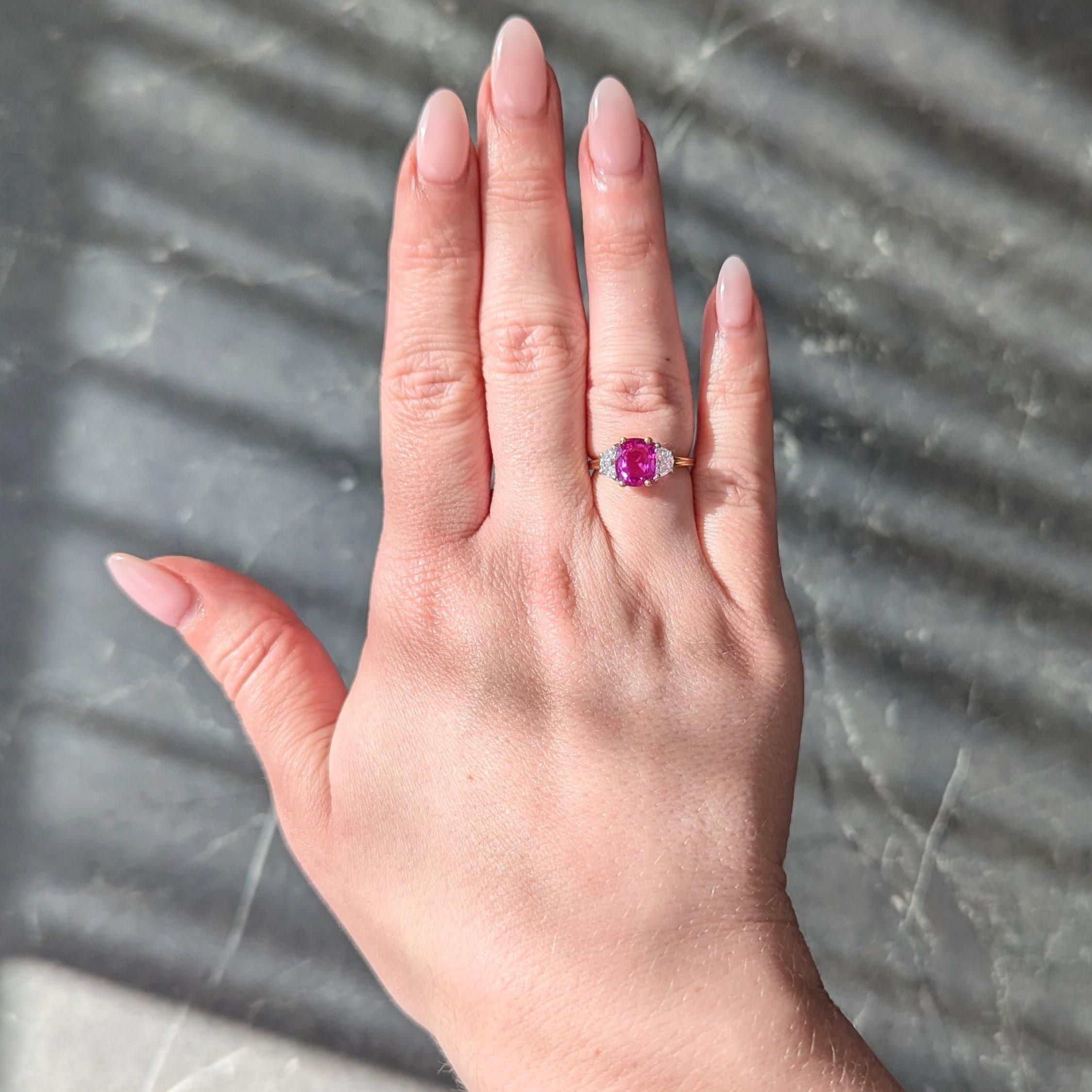 Centering a cushion cut sapphire weighing 2.60 carats - transparent vibrant medium pink in color
Natural Madagascar in origin - prong set in gold basket flanked by half-moon cut diamonds
Weighing approximately 0.70 carat total - G color with VS2