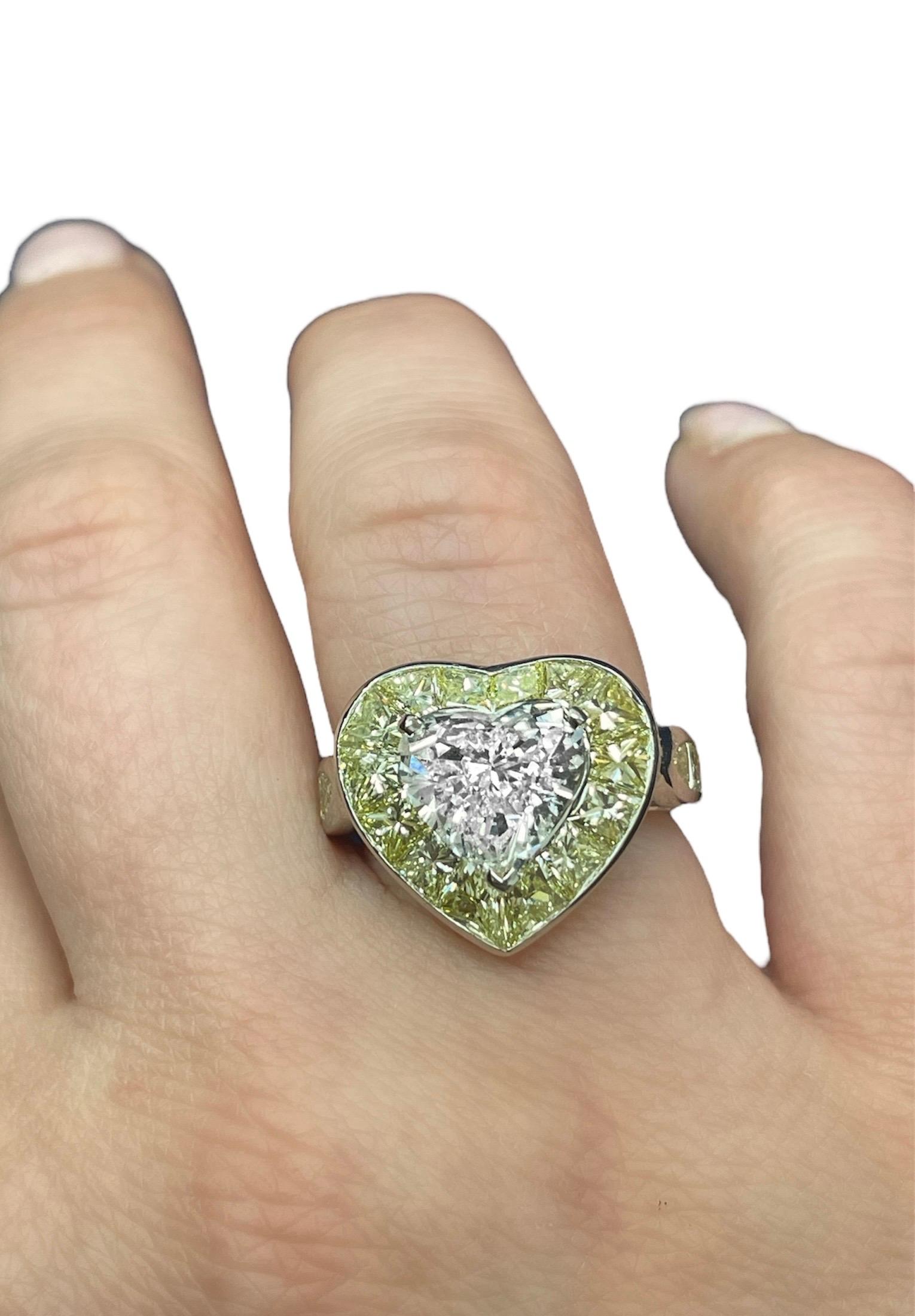 This beautiful engagement ring crafted by Oscar Heyman boasts one heart brilliant cut diamond weighing 3.15 carats with J color and SI2 clarity, surrounded by 20 calibre cut yellow diamonds weighing approximately 2.50 carats total. Mounted in