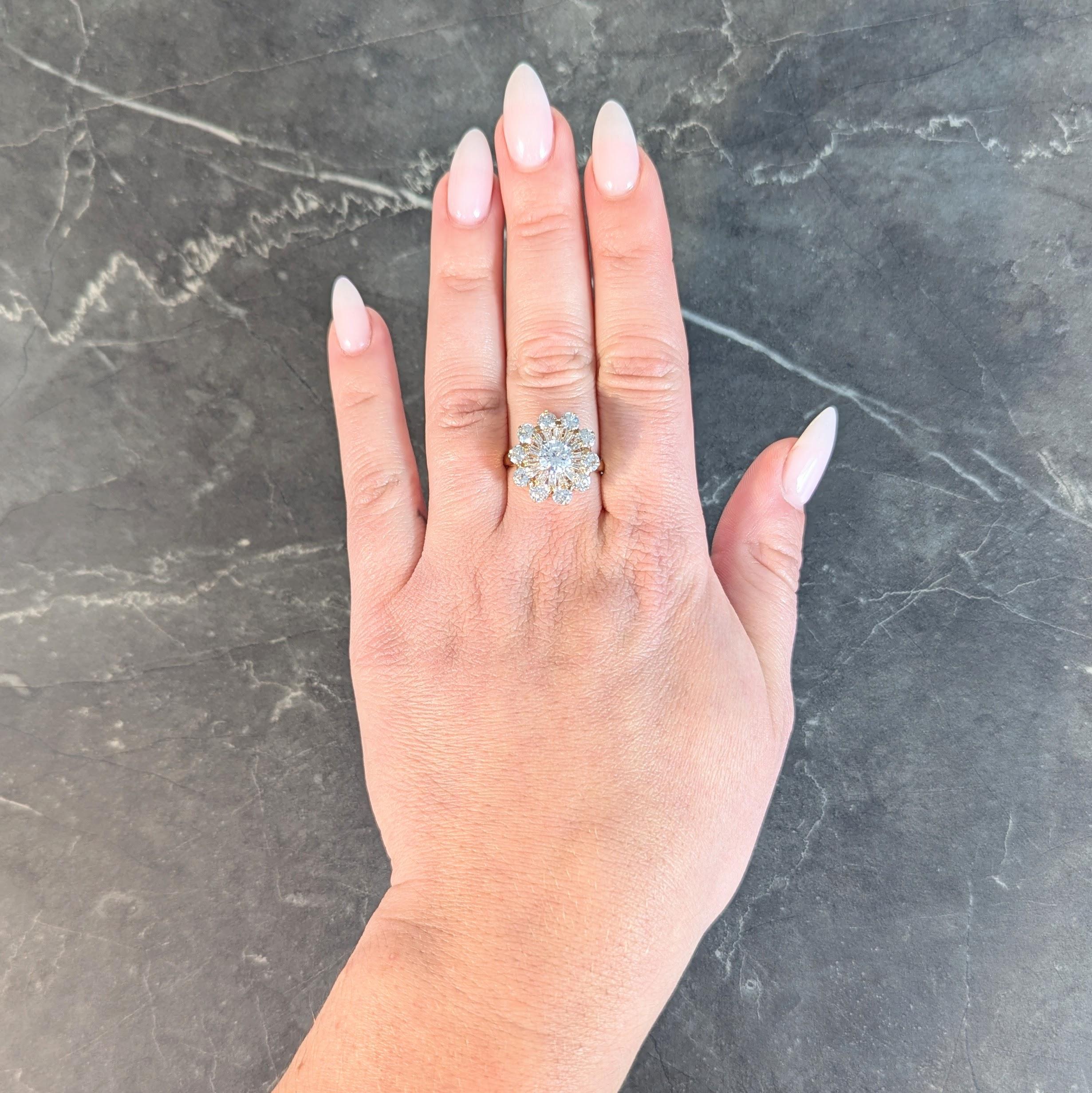 Centering a round brilliant cut diamond weighing approximately 0.82 carat
F color with VS1 clarity - prong set in platinum with a tiered halo surround
Immediate halo is ballerina style with prong set tapered baguettes
Weighing approximately 0.45