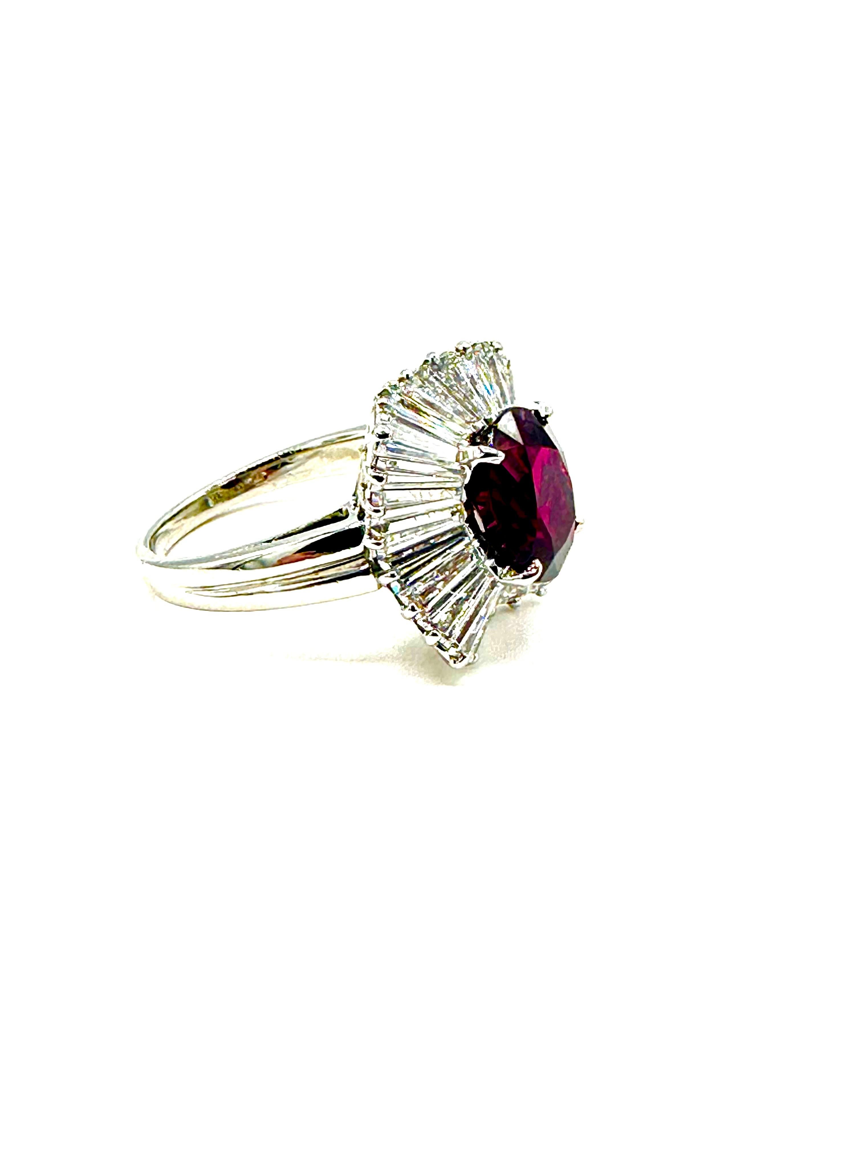 This is an amazingly beautiful ruby and diamond ballerina ring created by iconic designer, Oscar Heyman!  The 3.87 carat natural Ruby is set in four prongs, with a single row of tapered baguette Diamonds reaching outward, surrounding the Ruby in