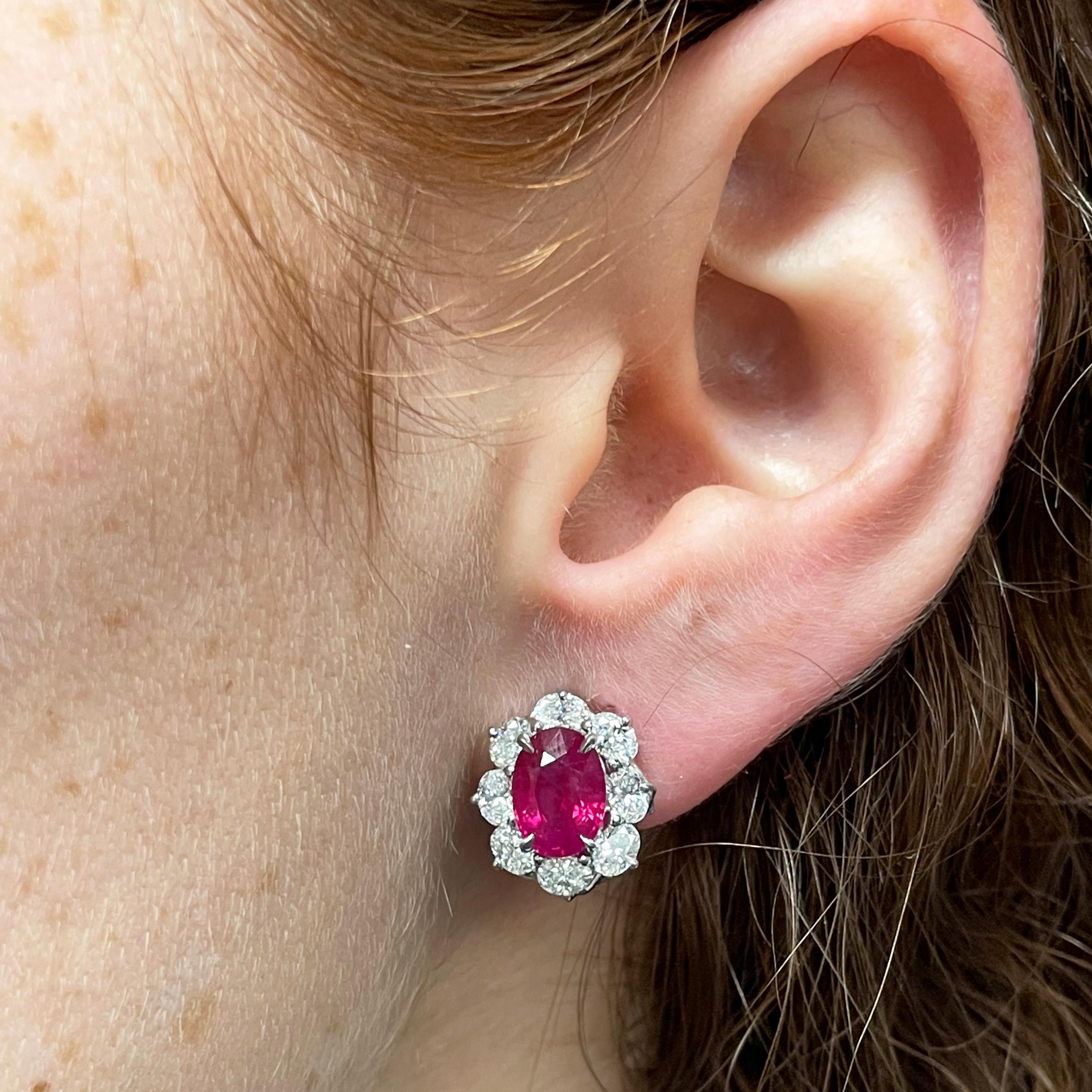 Oscar Heyman platinum 'entourage' earrings contain 4.09tcw Burma Rubies (GIA report) and 16 oval diamonds weighing 2.10tcw (F-G/VS quality). The face of the earrings measures 15mm tall by 13mm wide. They are stamped with the makers mark, PLAT, and