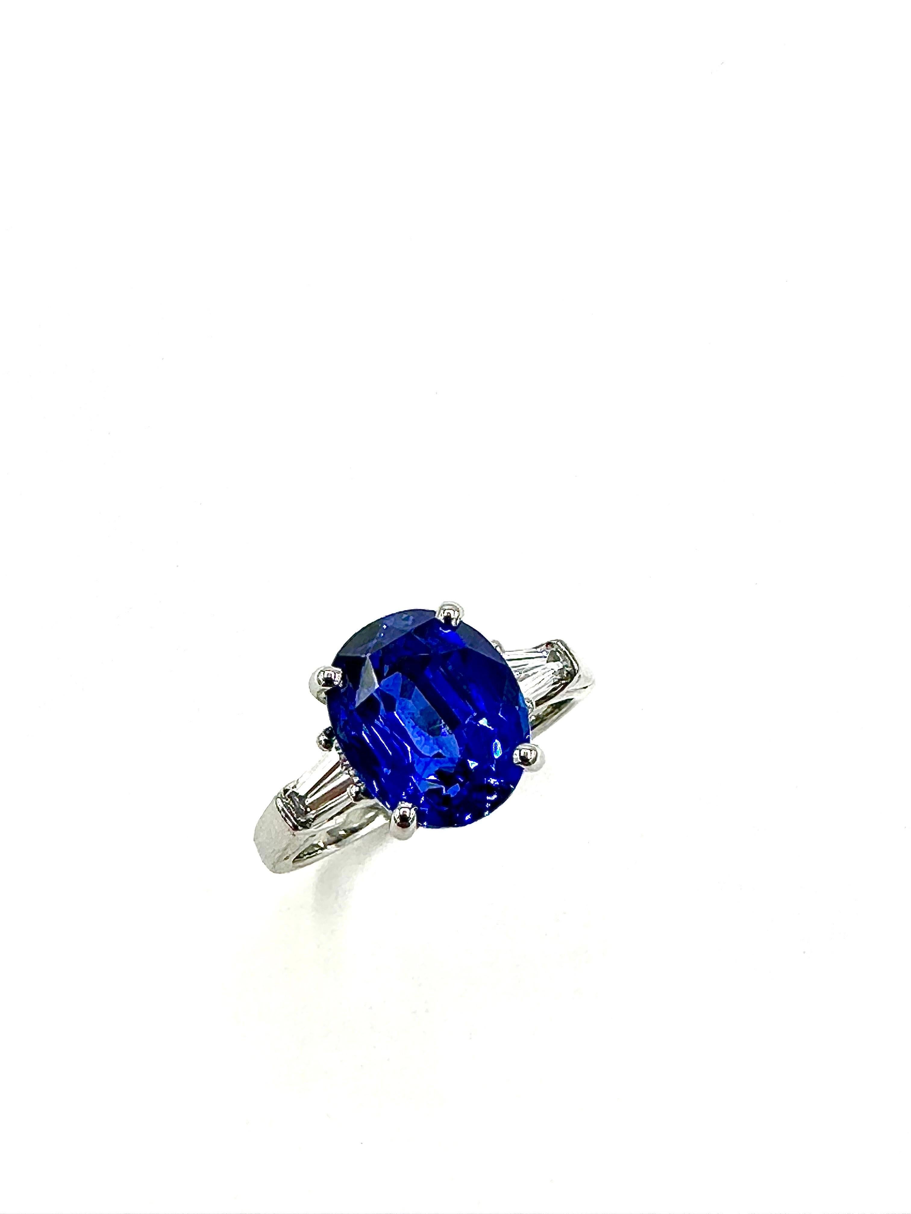 A stunning Sapphire and Diamond ring by the designers at Oscar Heyman Brothers.  The ring features a 4.82 carat center oval shaped Sapphire, set with a single tapered baguette Diamond on each side, weighing 0.36 carats total, in platinum.  The