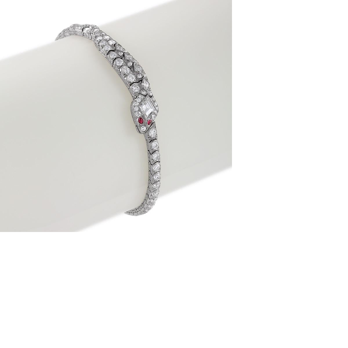 An American Art Deco platinum snake bracelet with diamonds and rubies by Oscar Heyman. The bracelet has a fancy square cut diamond head with 85 Old European cut round and square cut diamonds with an approximate total weight of 5.80 carats, and 2