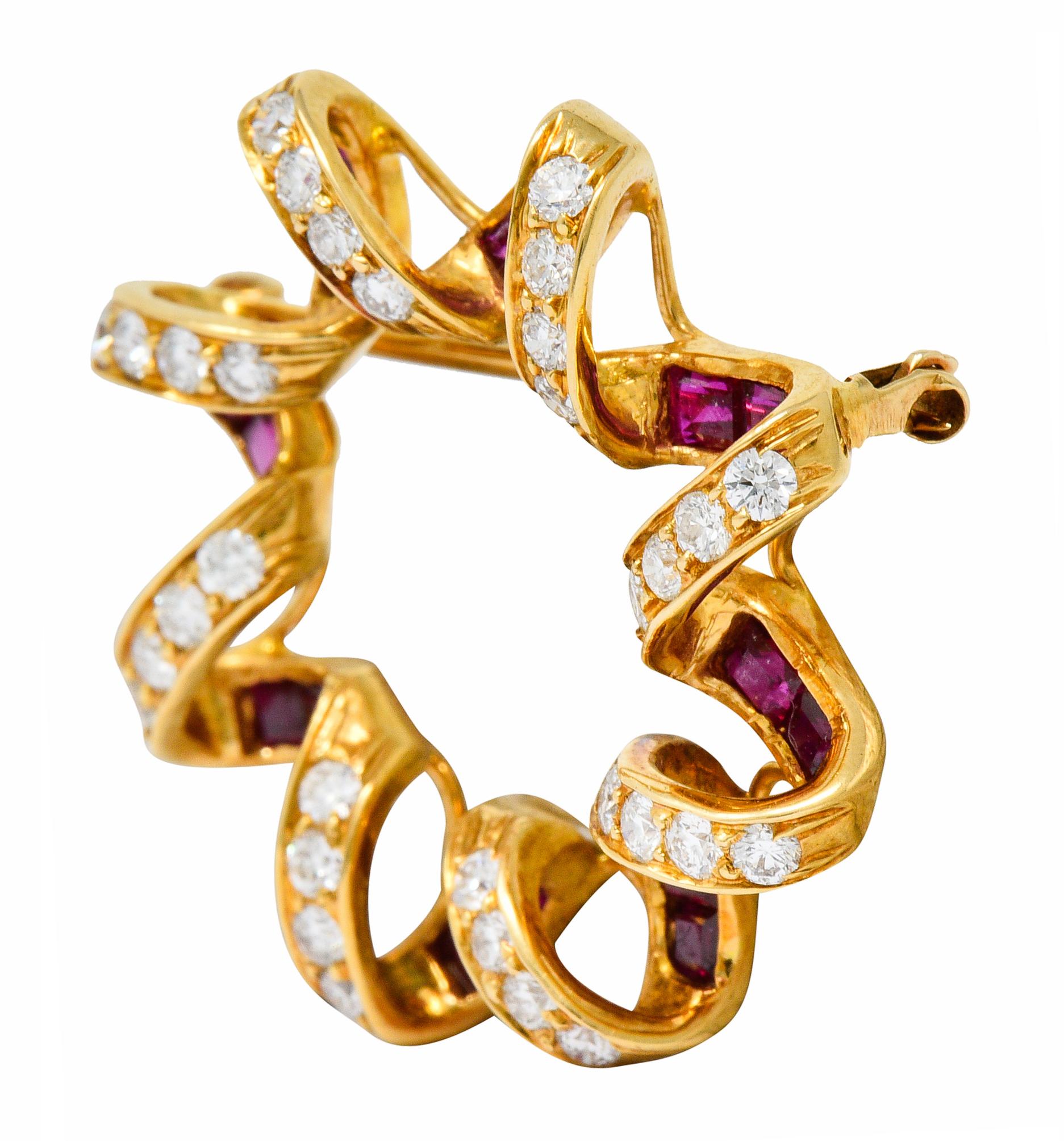 Designed as a stylized starburst with a spiraled gold border

Bead set with round brilliant cut diamonds weighing approximately 0.80 carat; F/G color with SI clarity

With channel set calibrè cut ruby weighing in total approximately 0.95 carat; red