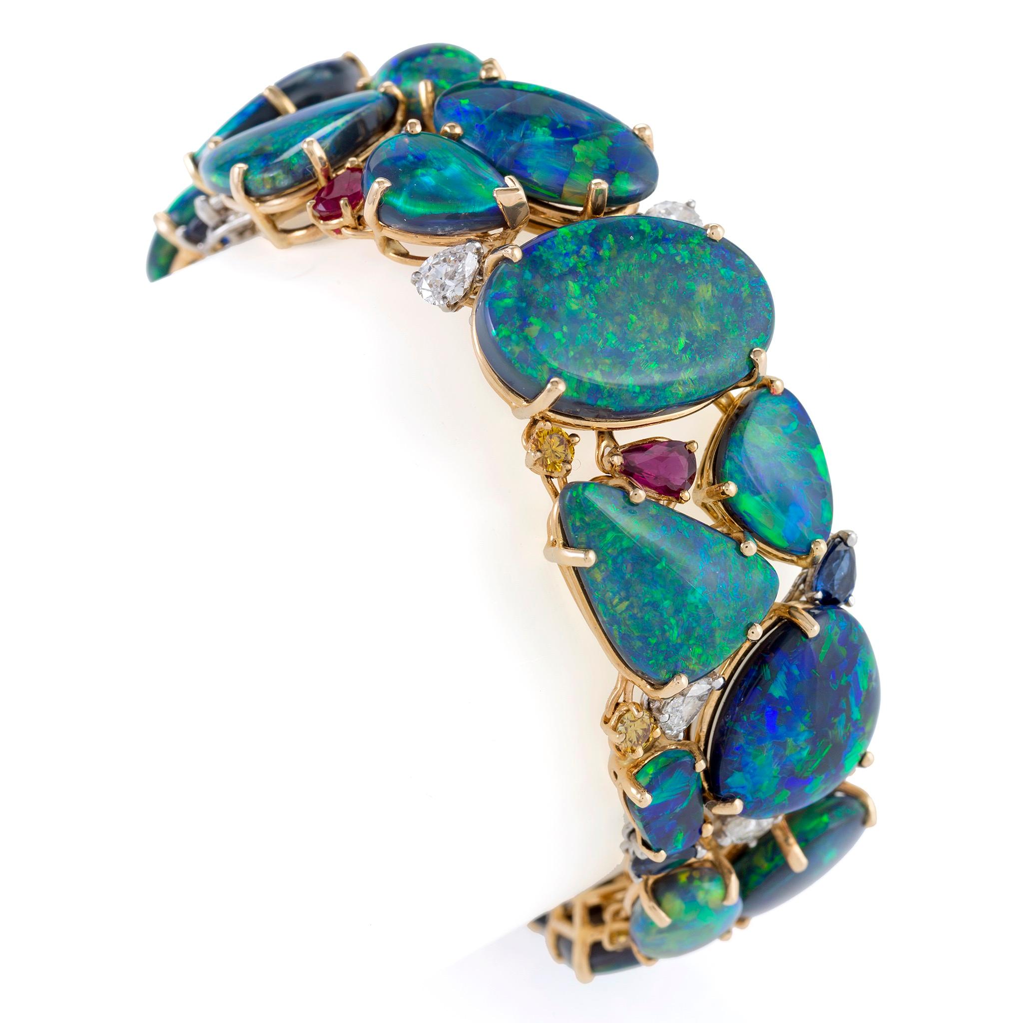 This contemporary bracelet created by Oscar Heyman & Brothers is composed of approximately eighty carats of variously shaped black opals, further enhanced by rubies, sapphires, yellow diamonds and diamonds, all set in gold and platinum. Centering a