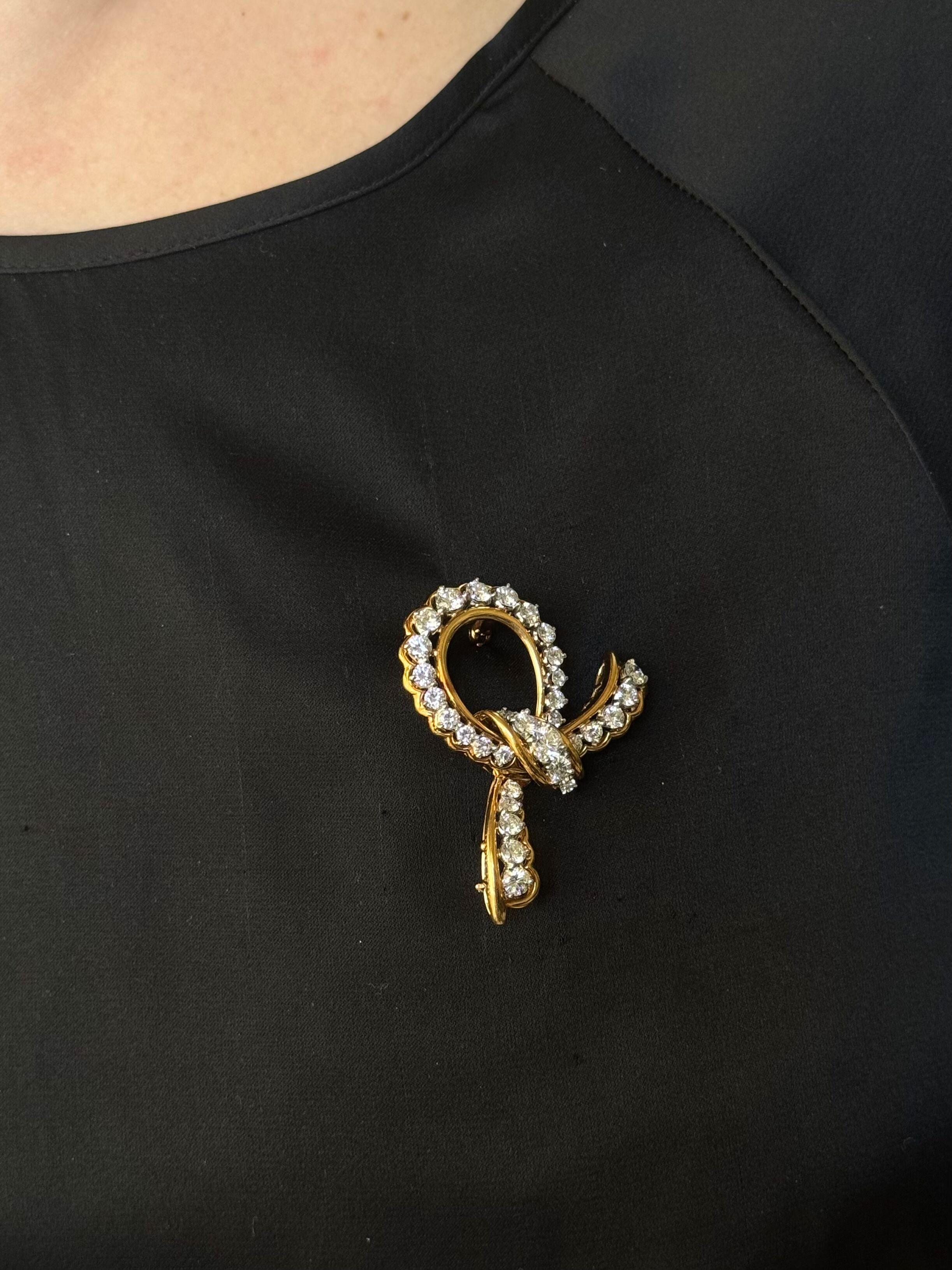 18k yellow gold and platinum ribbon brooch by Oscar Heyman Brothers, set with a total of approx. 3.50ctw FG/VVS diamonds. 
Brooch measures 1 7/8