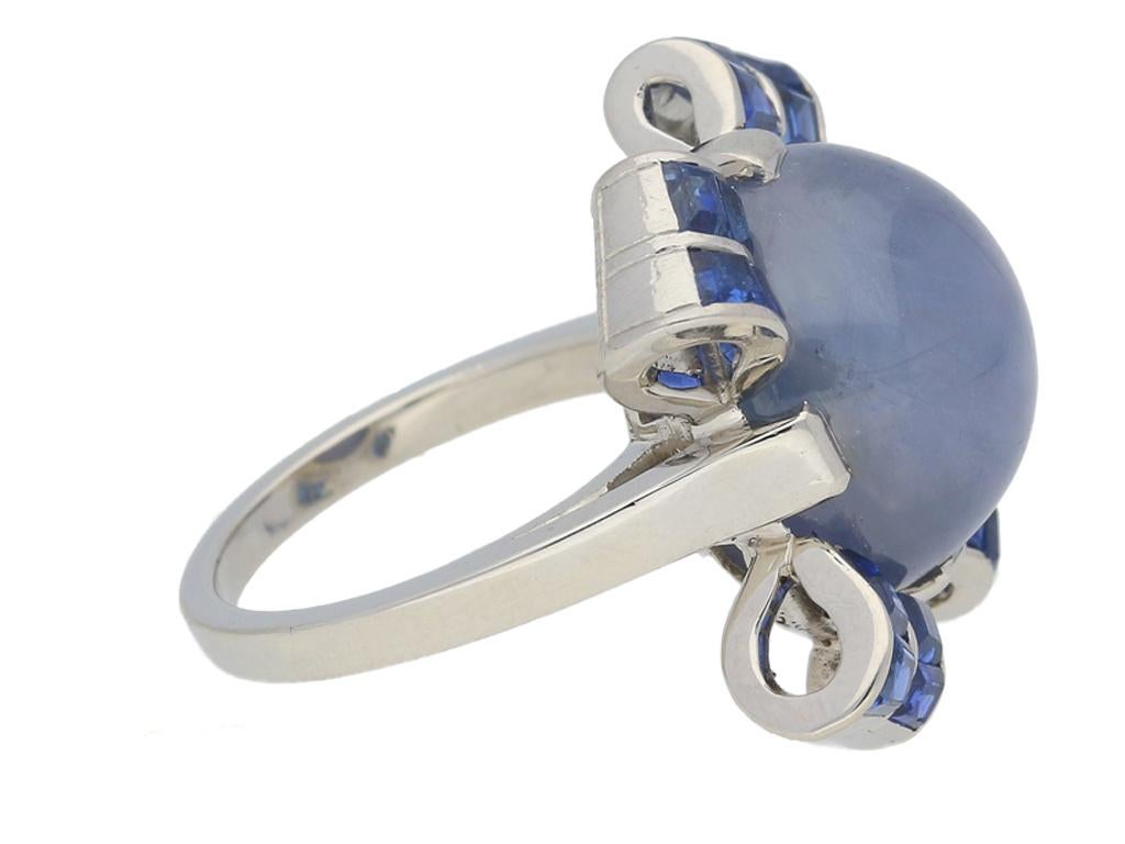 Oscar Heyman Brothers star sapphire cocktail ring. Centrally set with an oval cabochon natural unenhanced star sapphire in an open back claw setting with an approximate weight of 18.00 carats, further set with sixteen square calibre cut natural