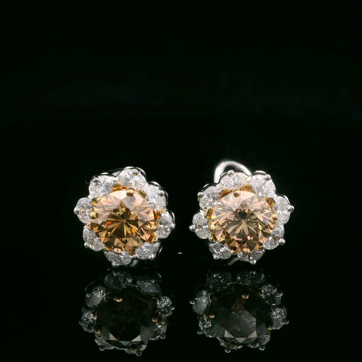 Oscar Heyman platinum and 18 karat gold earrings contain 2 cushion cognac diamonds (3.10cts VS2 & SI1) and 16 oval diamonds (1.08cts F-G/ VS). It is stamped with the makers mark, 18K and IRID PLAT, and serial number 706021.

Earrings measure 12mm H