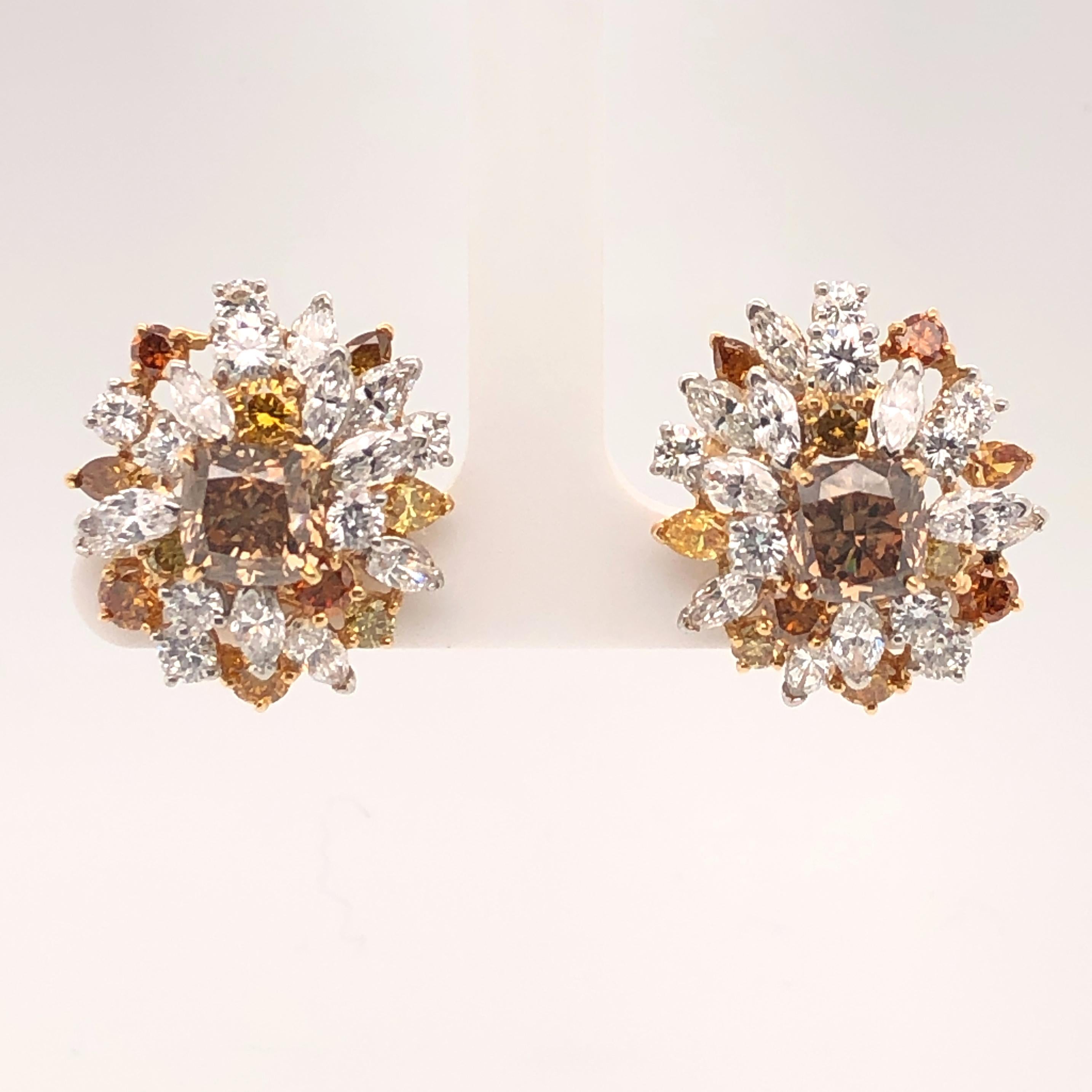 Oscar Heyman platinum and 18 karat gold earrings contain 2 cushion cognac diamonds (6.01cts, SI1 - SI2), 16 round diamonds 1.82cts, 20 marquise diamonds 3.00cts, and 20 assorted shape fancy colored diamonds 2.70cts. It is stamped with the makers