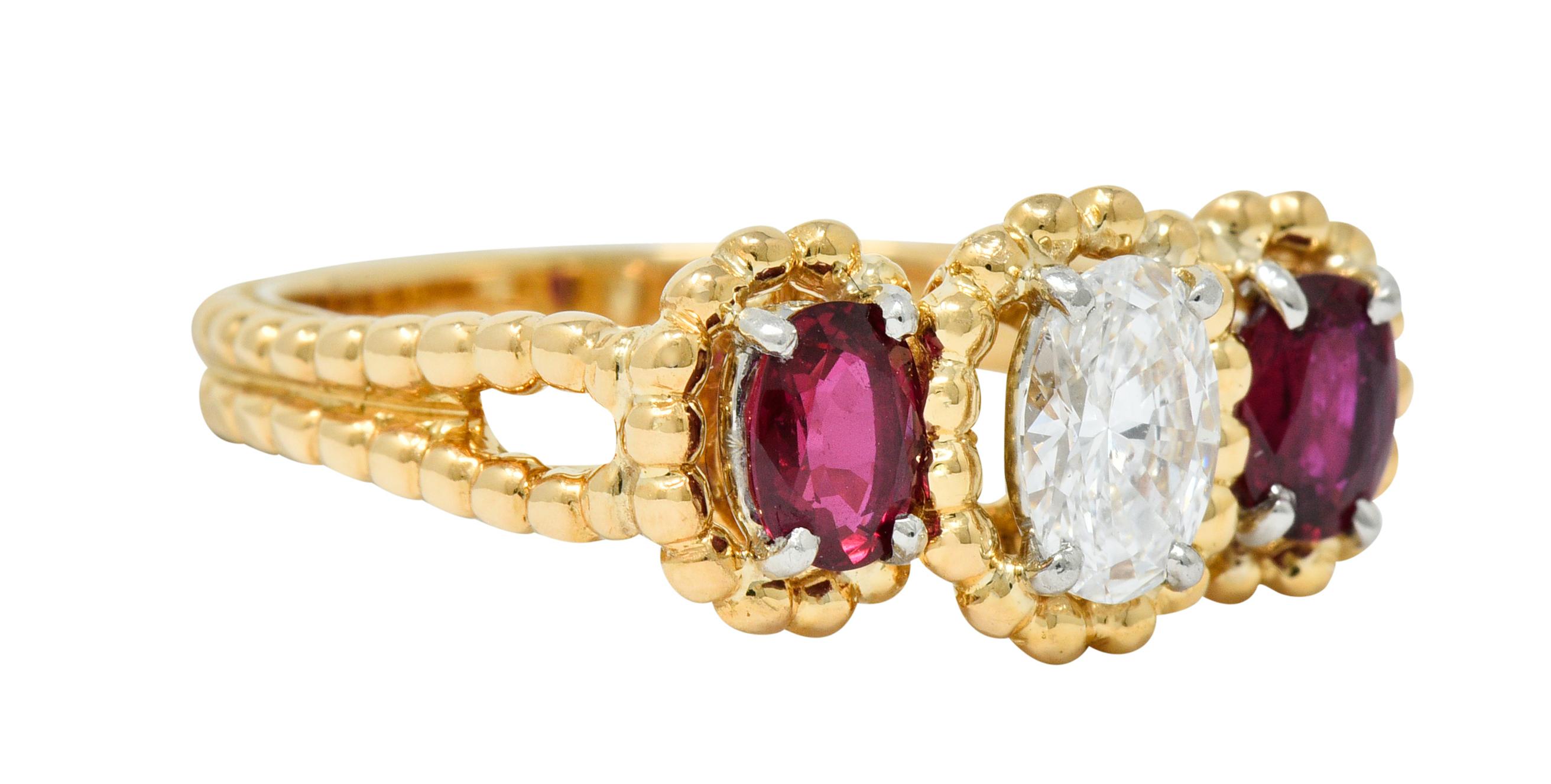 Three stone ring design is comprised of a yellow gold twisted rope motif

Centering an oval cut diamond weighing approximately 0.55 carat; F color with VS clarity

Flanked by two oval cut rubies, bright red, weighing in total approximately 0.85