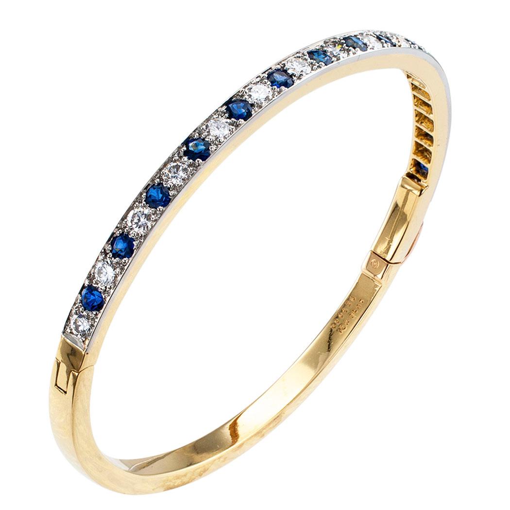 Oscar Heyman diamond sapphire gold and platinum bangle bracelet circa 1980. Designed as a course comprising fifteen round brilliant-cut diamonds totaling approximately 1.50 carats, approximately F – G color and VVS clarity, alternating with fourteen