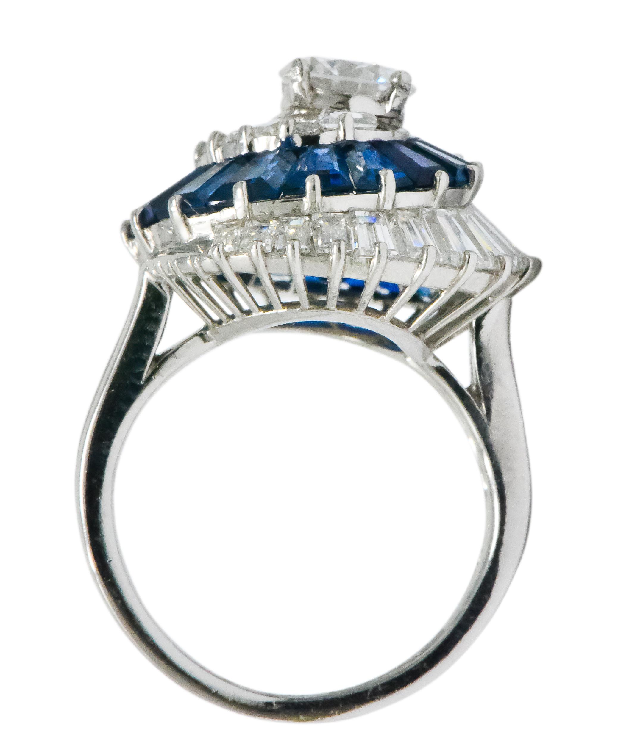 Oscar Heyman Diamond Sapphire Platinum Swirl Ring
Circa 1965
A round brilliant diamond center weighing .80 carat, D color, VS1 clarity centering a swirl of tapered baguette cut diamonds 
2.25 carat total weight of white diamonds, E-F color, VS