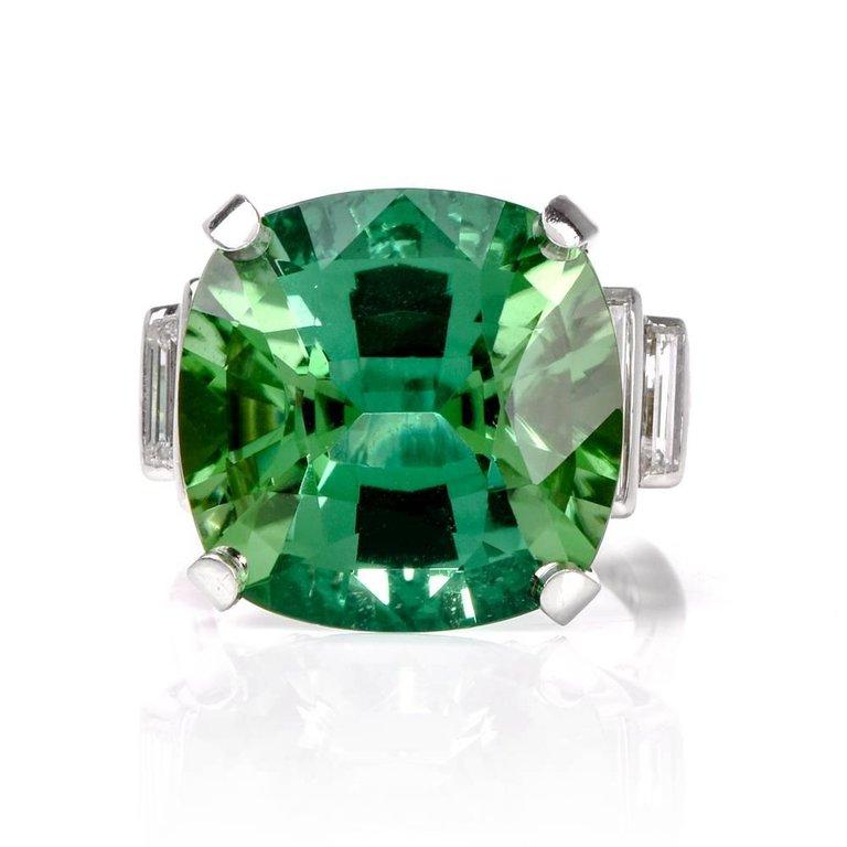 This impressive Oscar Heyman cocktail ring is crafted in solid platinum and exposes a prominent,  rare GIA certified cushion-cut Tourmaline of Blue-Green color, weighing approx. 17.39cts. Complimented by Four genuine baguette diamonds complement