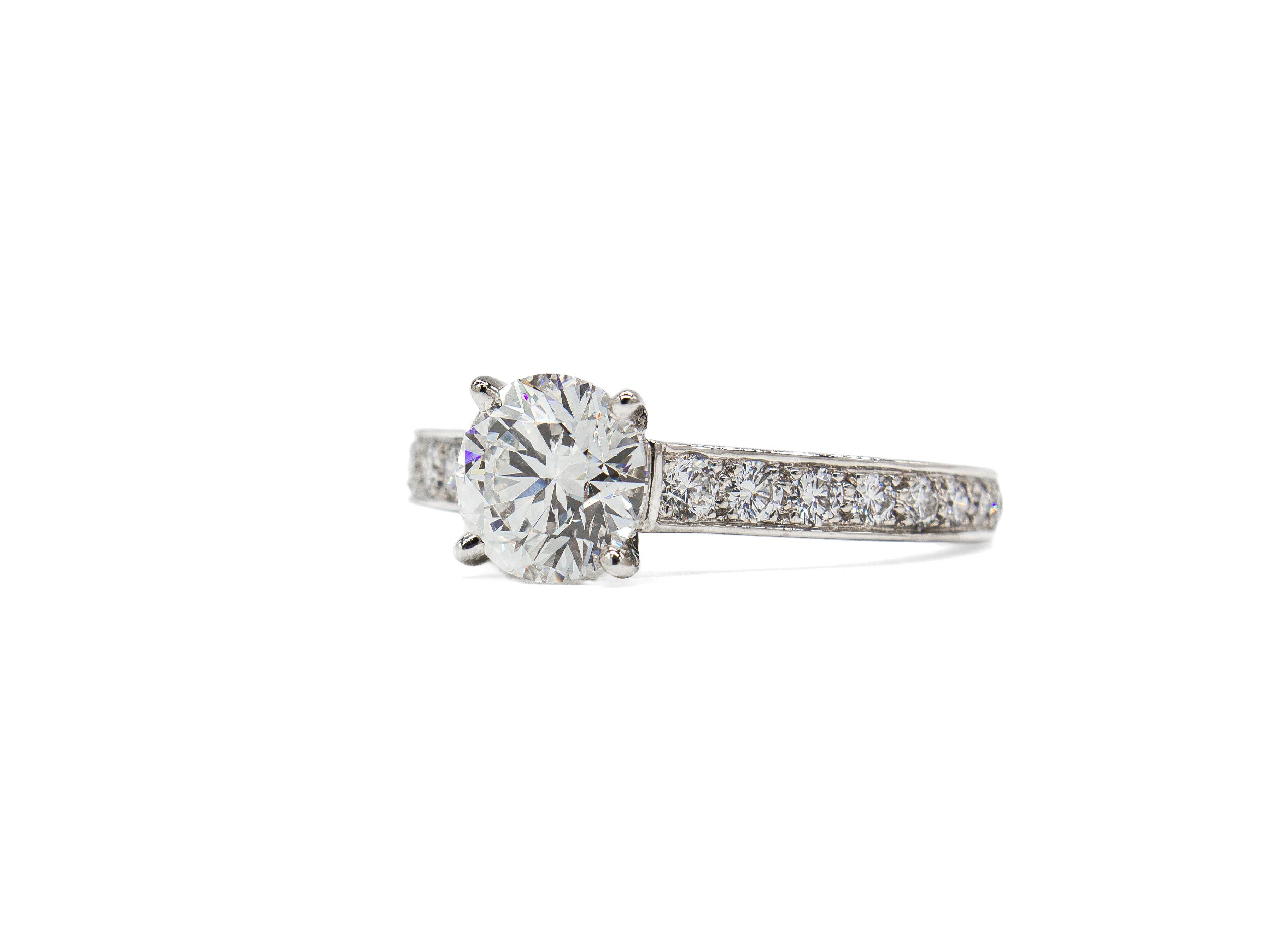 This timeless platinum ring by Oscar Heyman features a stunning 1.50 carat round brilliant diamond, certified by GIA as G color and VS1 clarity. The center stone is accented by 18 channel-set round brilliant diamonds with a total carat weight of