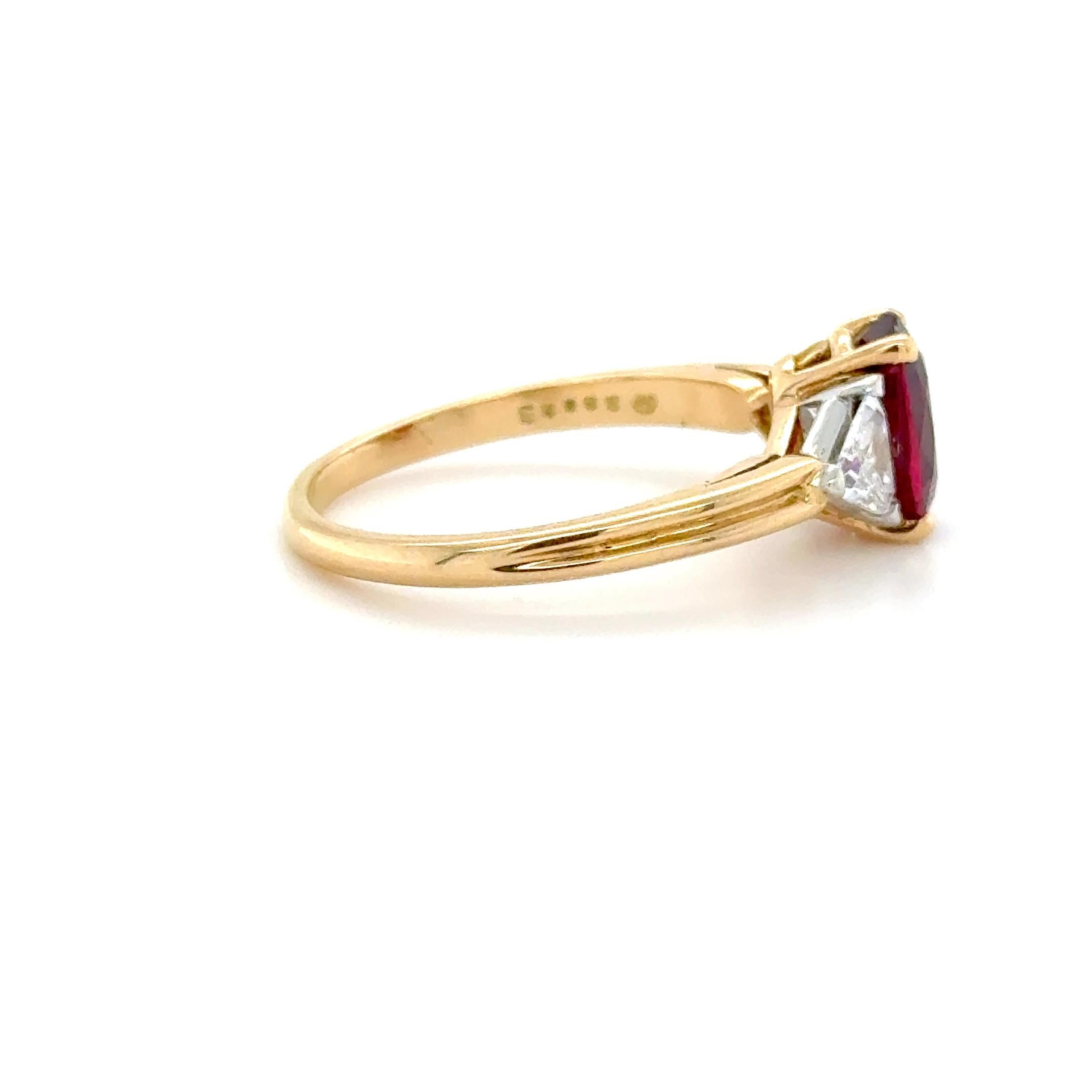 This beautifully classic ring designed by Oscar Heyman boasts a bright oval brilliant cut ruby measuring 8.96 x 6.13 x 4.18 mm and weighing approximately 2.00 carats, flanked by two top quality trillion cut diamonds weighing approximately 0.60 carat