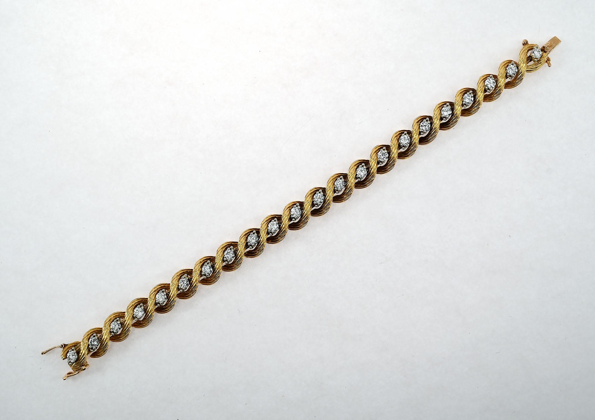 Twenty two round cut diamonds are set between the criss cross links of this Oscar Heyman gold bracelet. Total weight of the diamonds is 2.69 carats. The bracelet is 6 3/4 inches in length and slightly more than 1/3 of an inch in width. It is