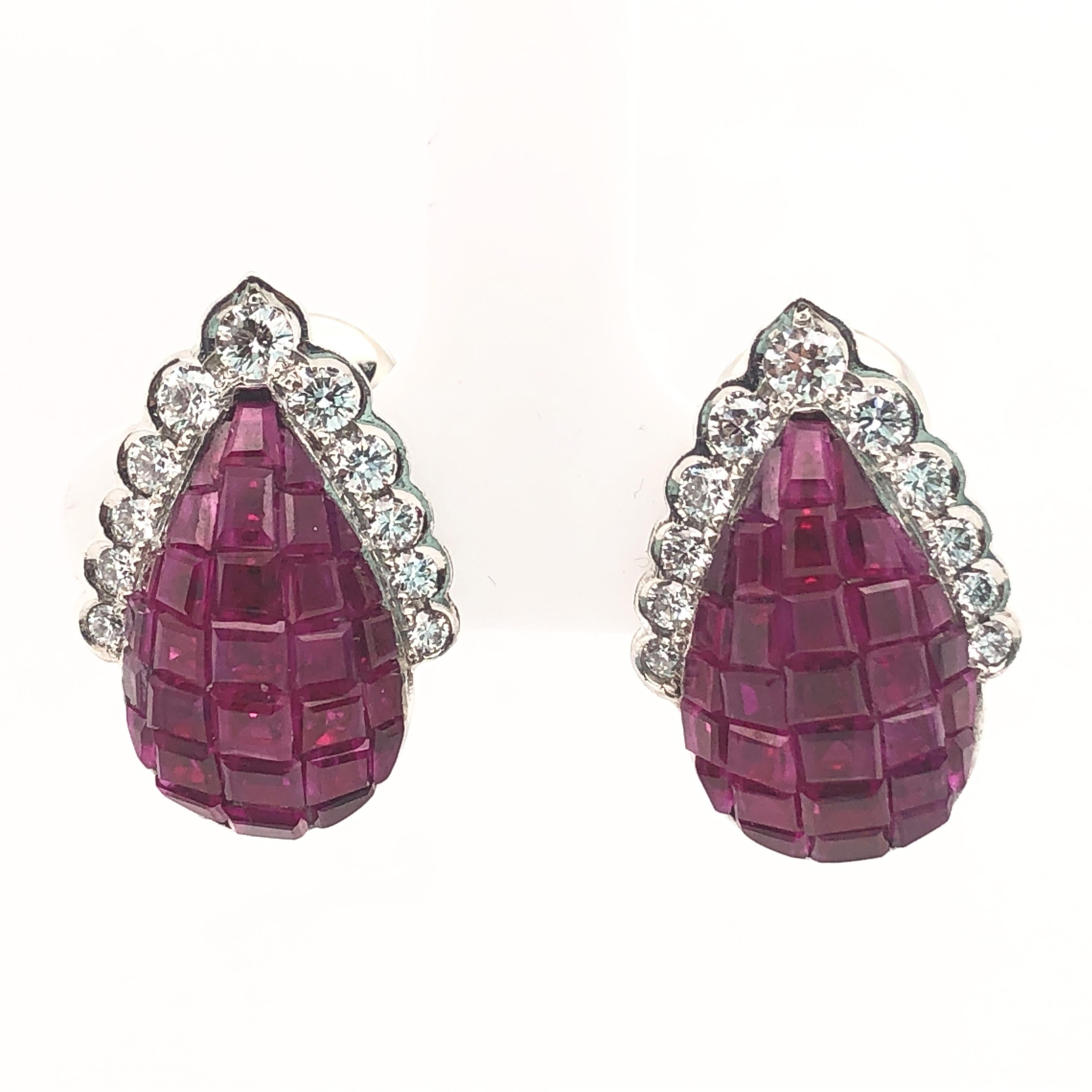 Oscar Heyman platinum earrings contain invisibly set rubies (approx 12cts) surrounded by round diamonds.  It is stamped with the makers mark, IRID PLAT, and serial number 78880.

Earrings measure 20mm L x 14mm W, and have clip backs. A post can be