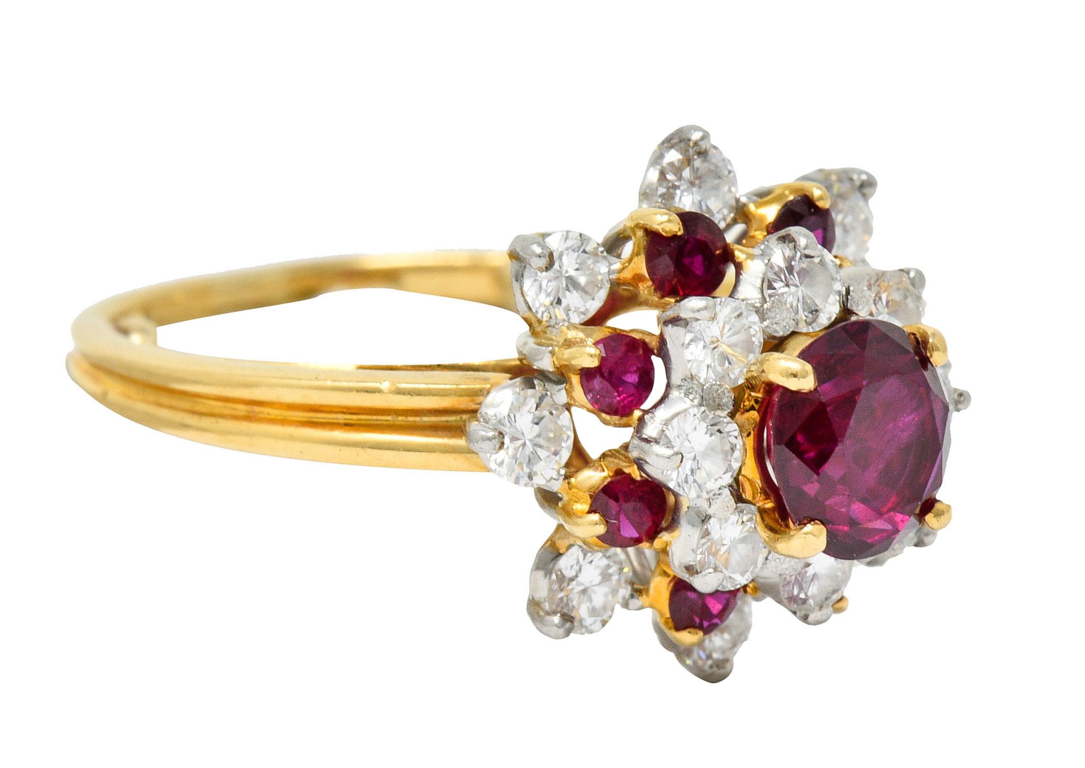 Cluster style ring with platinum and gold tiers of prong set rubies and diamonds

Centering a round cut Thai ruby with vibrant red color and weighs approximately 1.00 carat

Surrounded by round brilliant cut diamonds weighing in total approximately