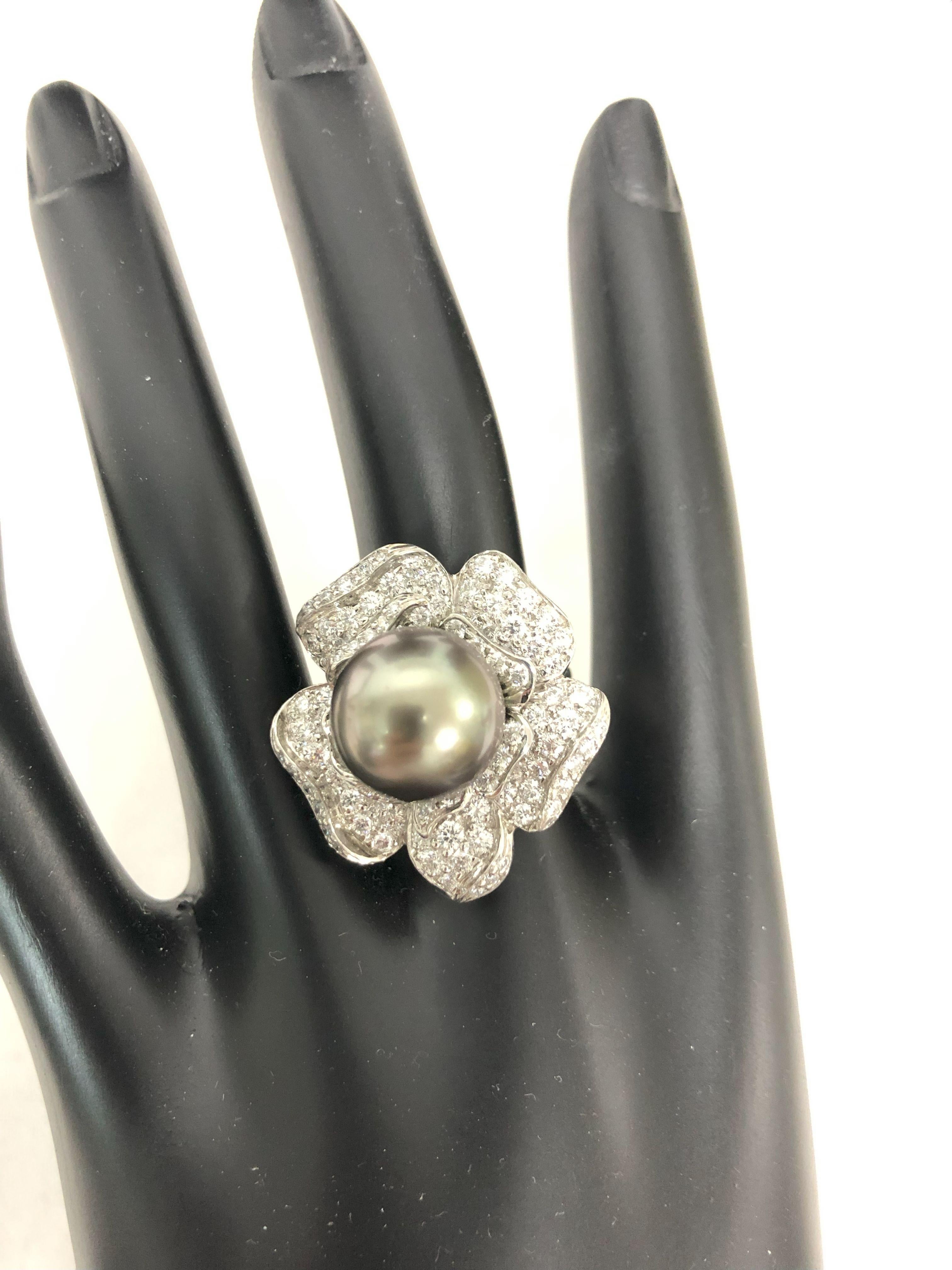 Oscar Heyman platinum ring contains a stunning 12mm Tahitian Pearl at the center of a flower composed of 102 round diamonds weighing 2.49cts (F-G/VS) that are bead set. It is stamped with the makers mark, IRID PLAT, and serial number 302442. The