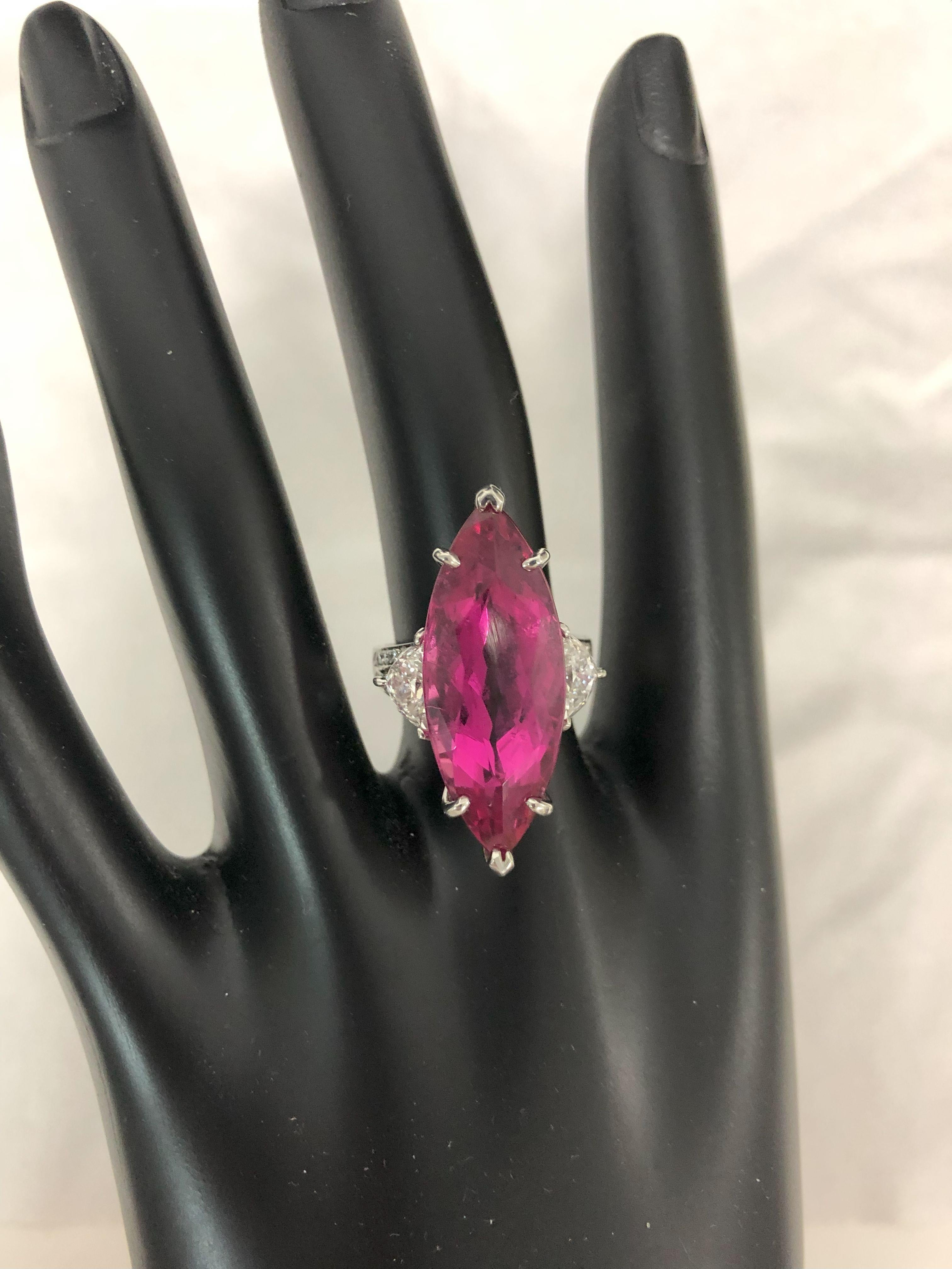 Oscar Heyman platinum ring contains a 15.74ct marquise rubellite tourmaline (with a CDC report) with two epaulette diamonds on either side with a total weight of 1.35cts (E/ VS) and a split shank with pave diamond detail. The center stone measures