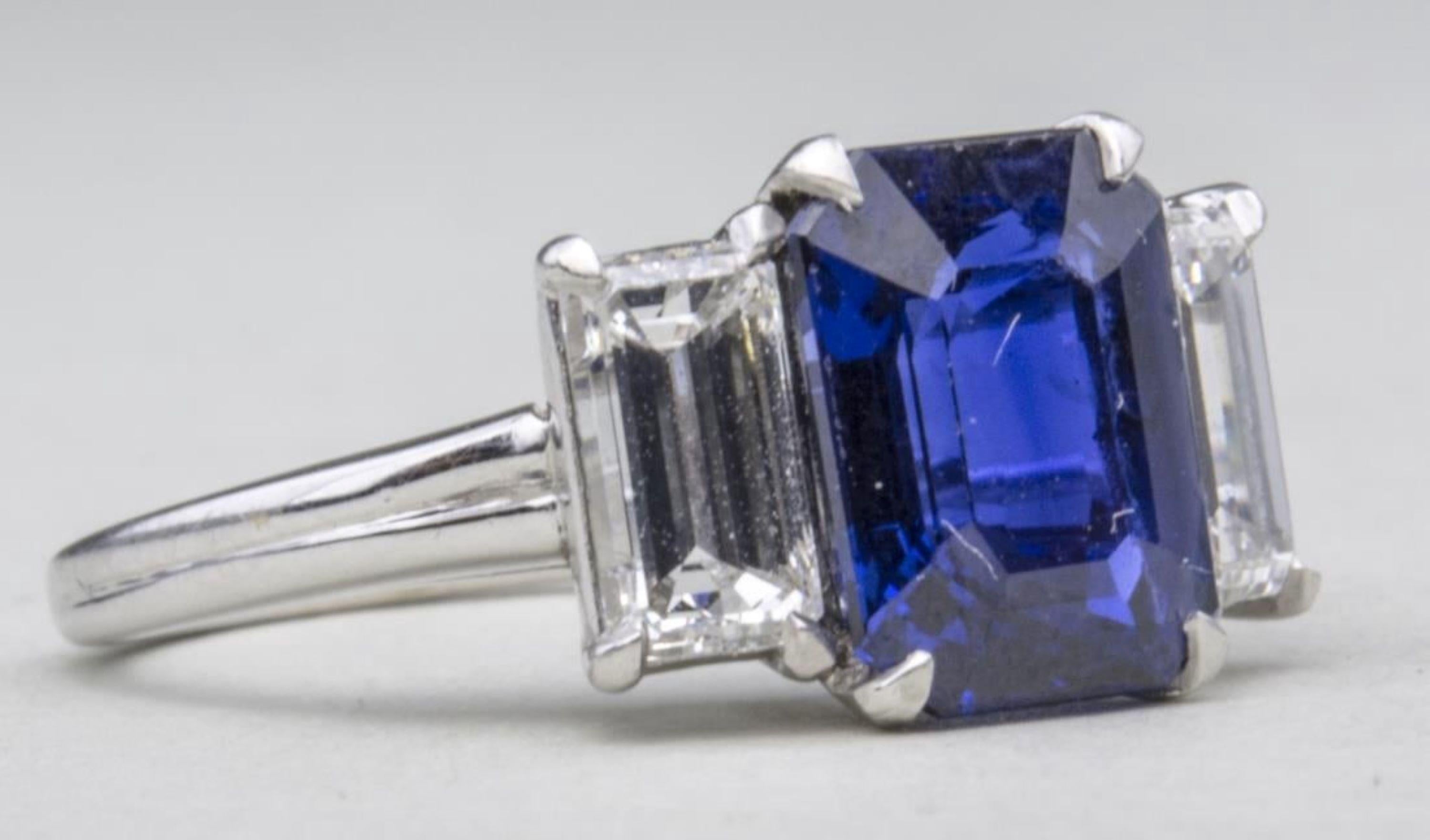 Platinum and 18k white gold ring with a center emerald cut sapphire, weighing 2.93 carats, flanked by two emerald cut diamonds, total 1.17 carats, signed HB and 35321, accompanied by AGL report  #CS1074940, dated May 20, 2016, stating natural