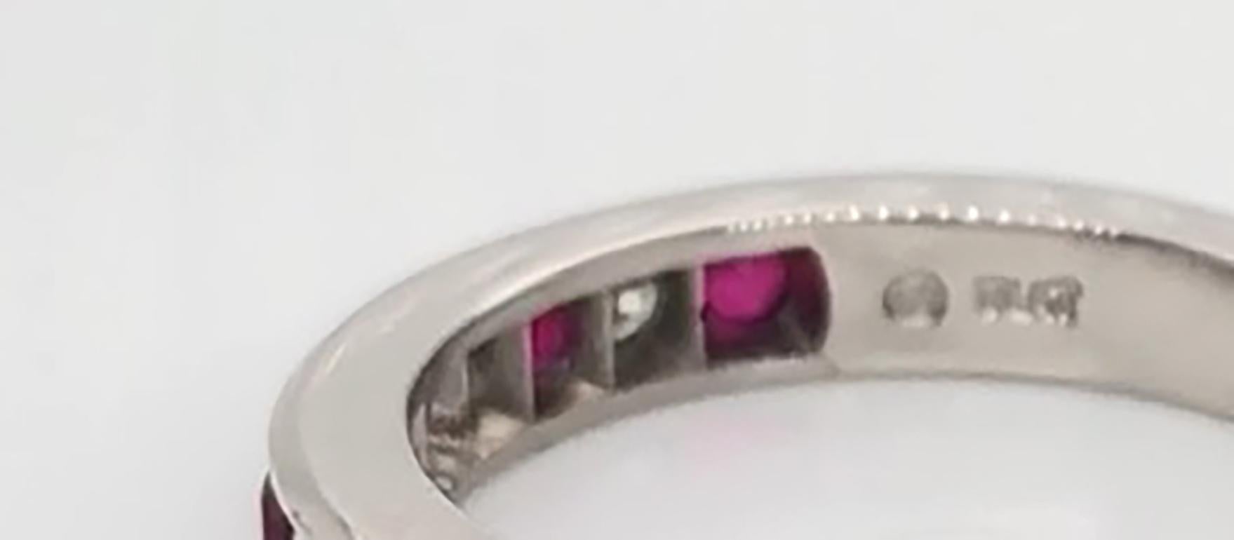 Oscar Heyman platinum ruby and diamond partway wedding band contains 4 Round Diamonds (F-G/ VS+ quality) weighing 0.16cts and 5 Round Rubies weighing 0.40cts that are channel set. It is 3.0mm wide and stamped with the makers mark, 18K, and serial
