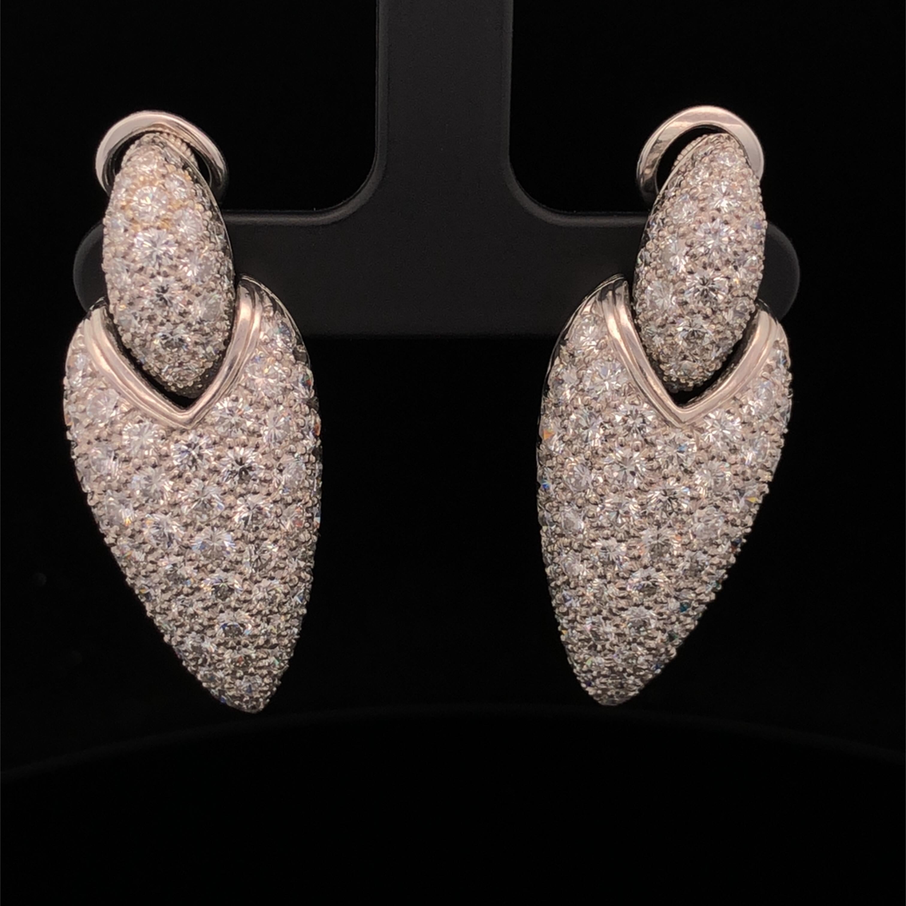 Oscar Heyman platinum 'door knocker' style earrings contain 8.58tcw of round diamonds, F-G/VS quality. They are individually stamped with the makers mark, IRID PLAT, and serial number 705038. Earrings have clips but we can add posts at no additional