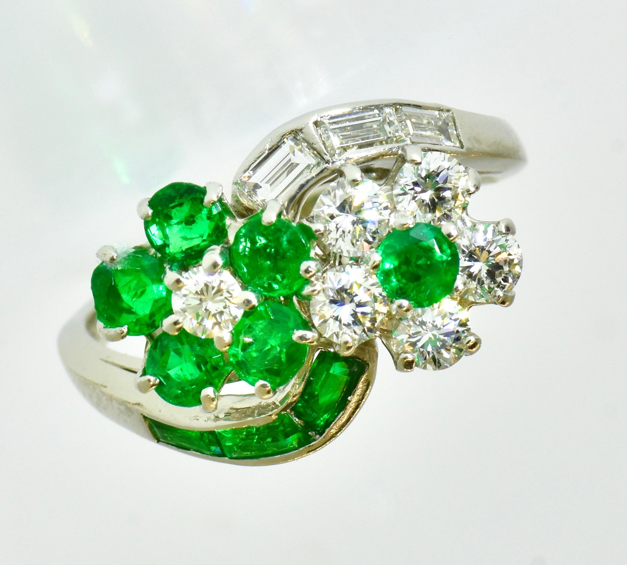 Oscar Heyman vintage ring possessing their inventory number,  62514. This charming ring was made in platinum with fine diamonds and emeralds in a bypass flower motif.  Oscar Heyman has confirmed this piece was made by them in 1962.  

This is