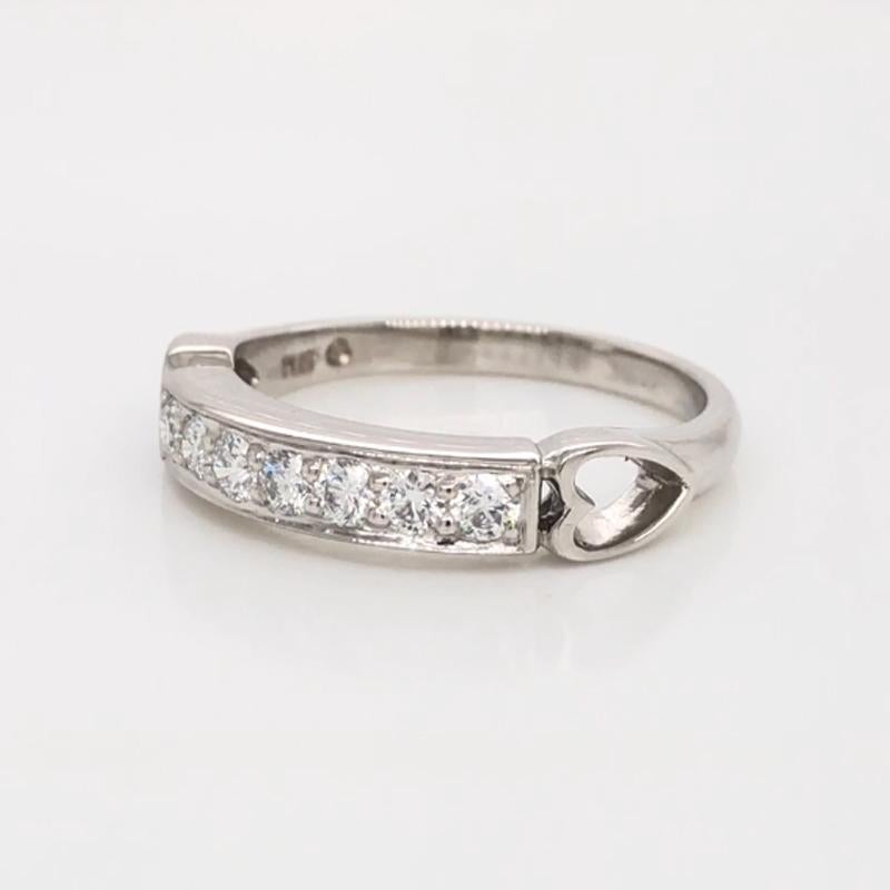 Oscar Heyman platinum diamond wedding band ring contains 7 Round Diamonds (F-G/ VS+ quality) weighing 0.30cts that are bead set. It is accented with two carved hearts. It is 3.5mm wide and stamped with the makers mark, IRID PLAT, and serial number