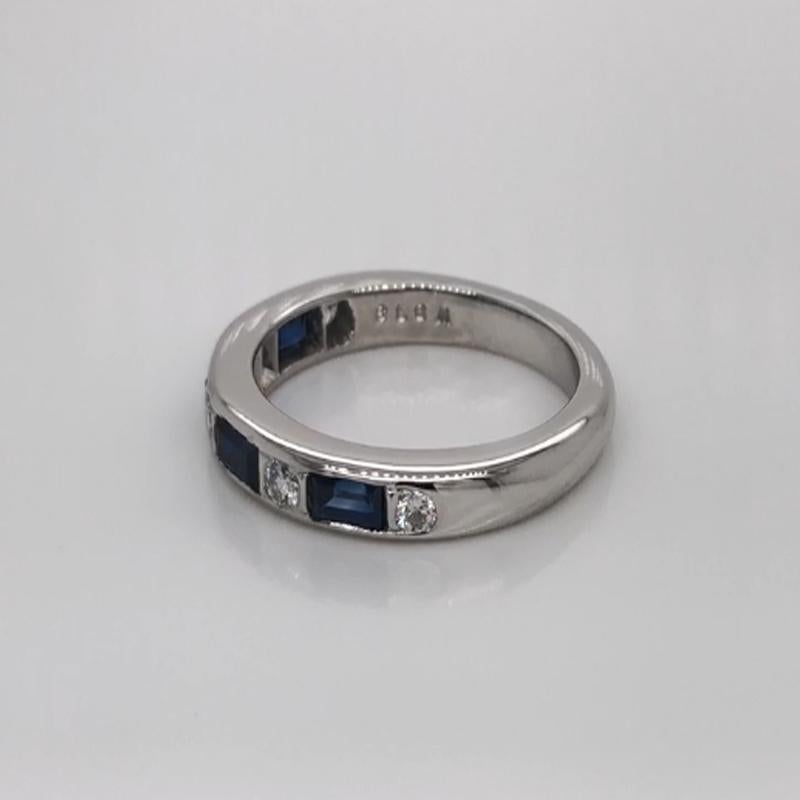 Oscar Heyman platinum sapphire and diamond partway wedding band ring contains 5 Round Diamonds (F-G/ VS+ quality) weighing 0.20cts and 4 Baguette Sapphires weighing 0.74cts that are channel set. It is 3mm wide and stamped with the makers mark, IRID