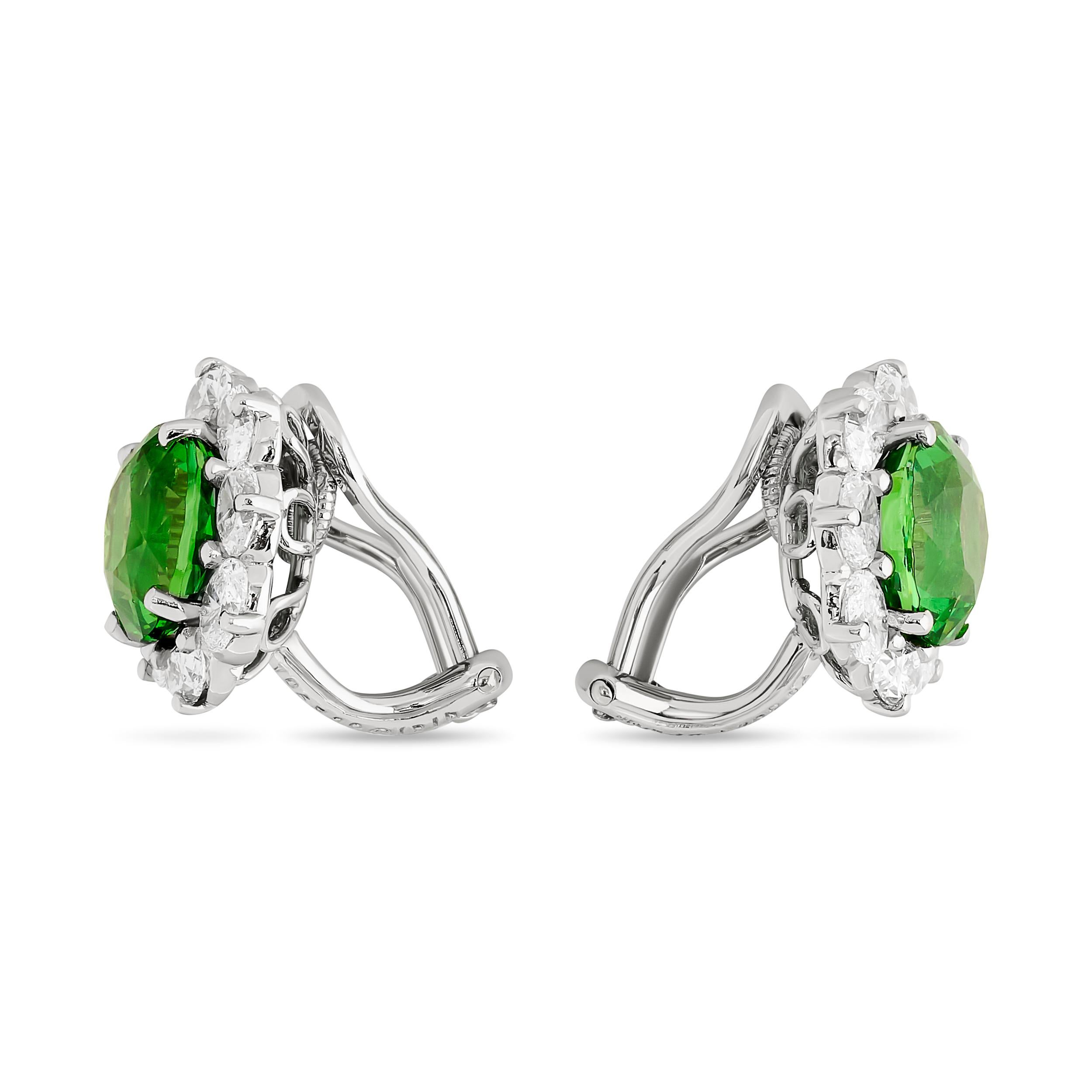 Adorn yourself in lush beauty with these Oscar Heyman vibrant, green tsavorite garnet and diamond halo earrings.

These earrings feature two oval green tsavorite garnets that weigh approximately 6.15 carats. There are also 16 oval diamonds totaling