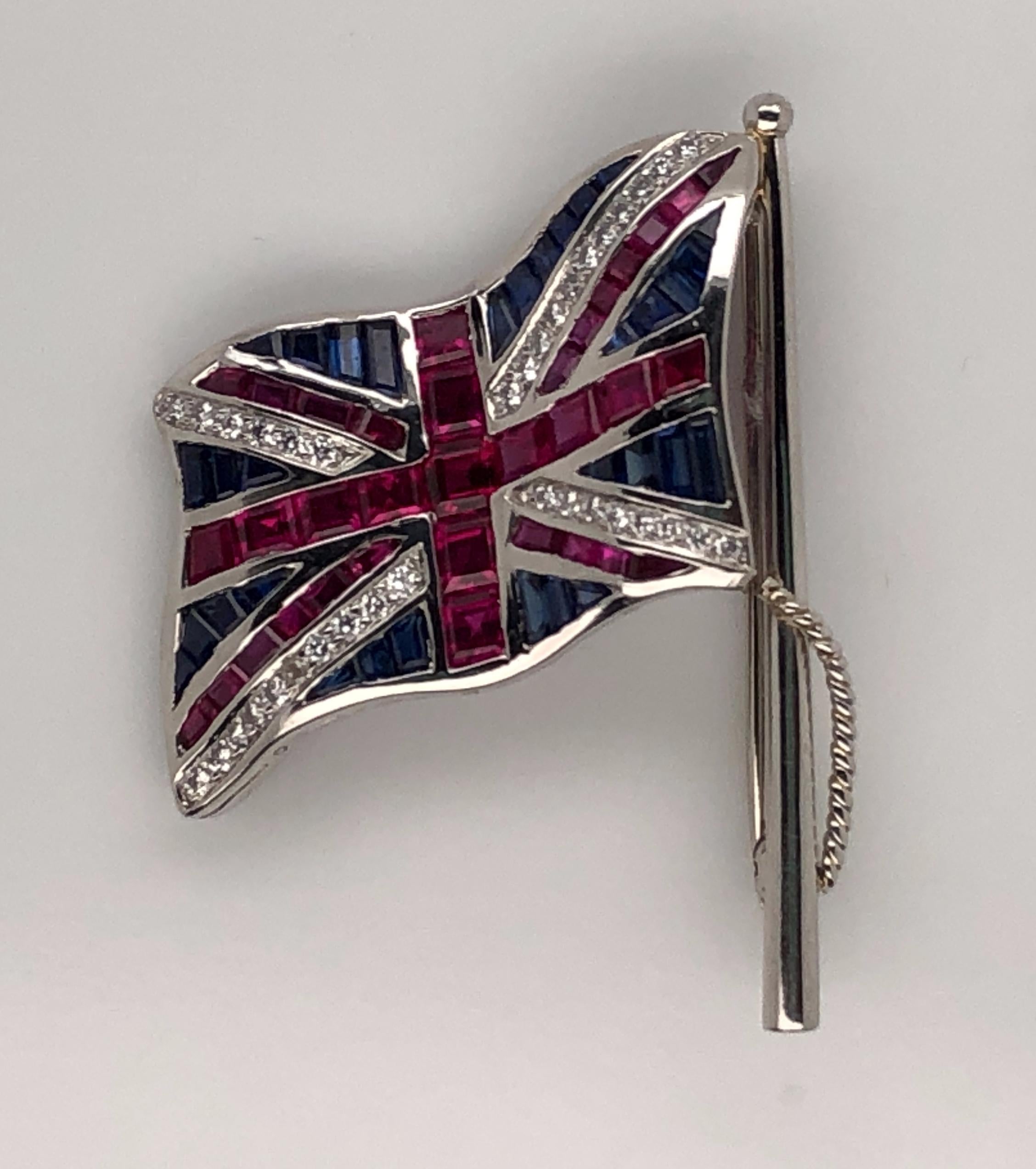 Oscar Heyman platinum Union Jack flag brooch contains rubies (2.63cts), sapphires (1.59cts) and diamonds (0.33cts). It is stamped with the makers mark, IRID PLAT, and serial number 200826.

Flag pole is 38mm in length, flag measures 25mm x
