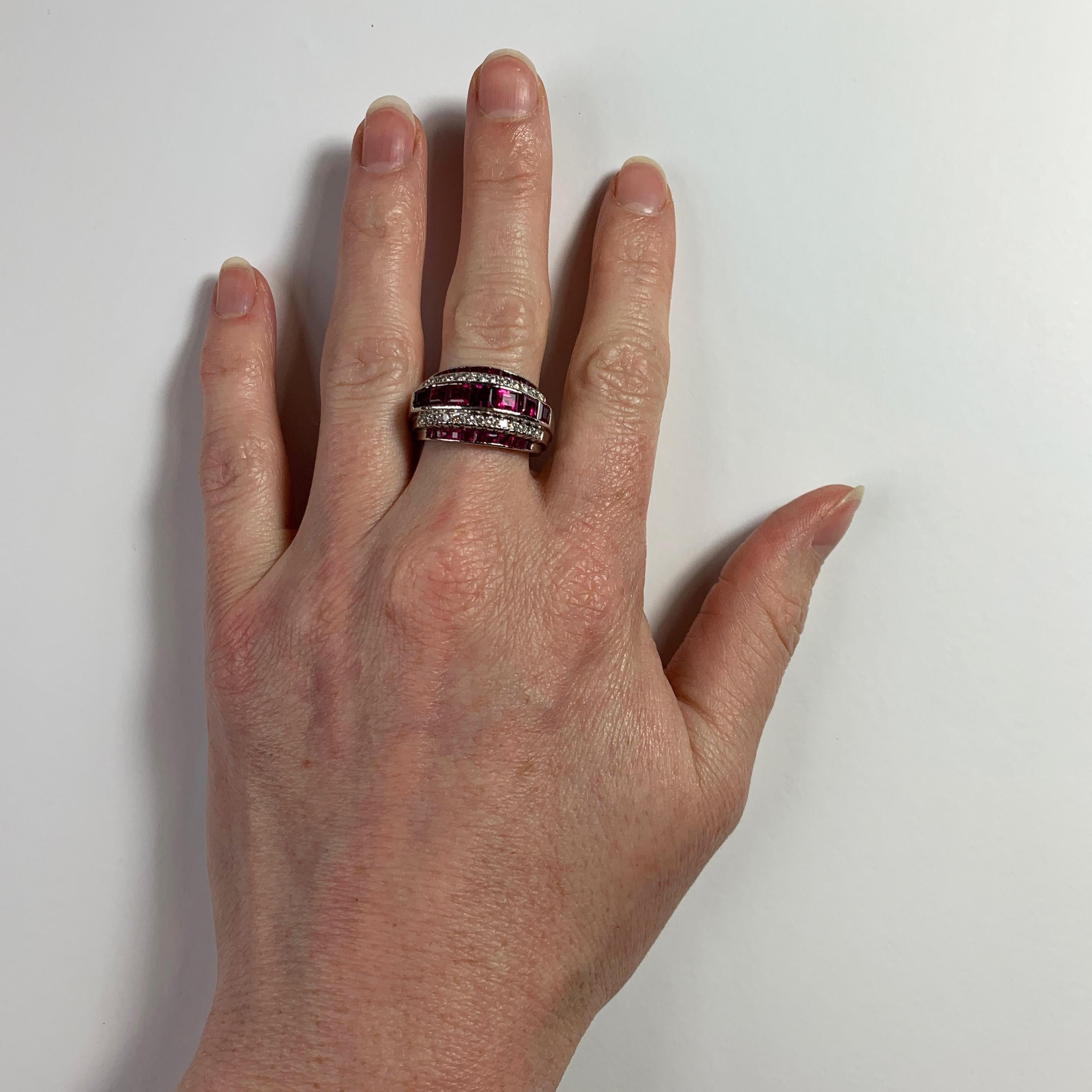 A platinum, ruby and diamond ring by Oscar Heyman Brothers (OHB) set with 29 step cut red rubies and 26 round brilliant cut white diamonds. The rubies show no indications of heat treatment and have inclusions which indicate Burmese origin. Numbered