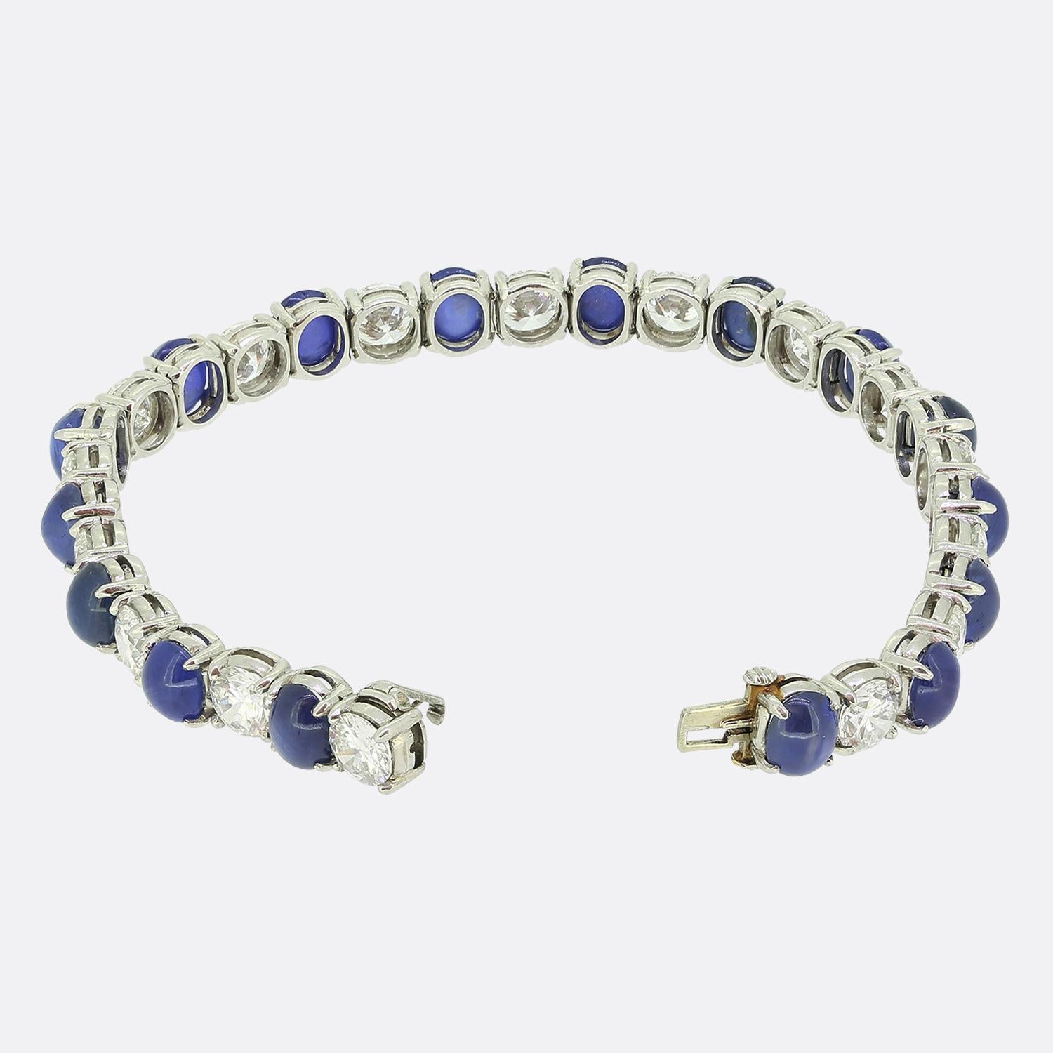 Here we have a sophisticated bracelet from the world renowned jewellery designer, Oscar Heyman. This piece has been crafted from platinum and features alternating cabochon-cut blue sapphires alongside round brilliant-cut white diamonds. The