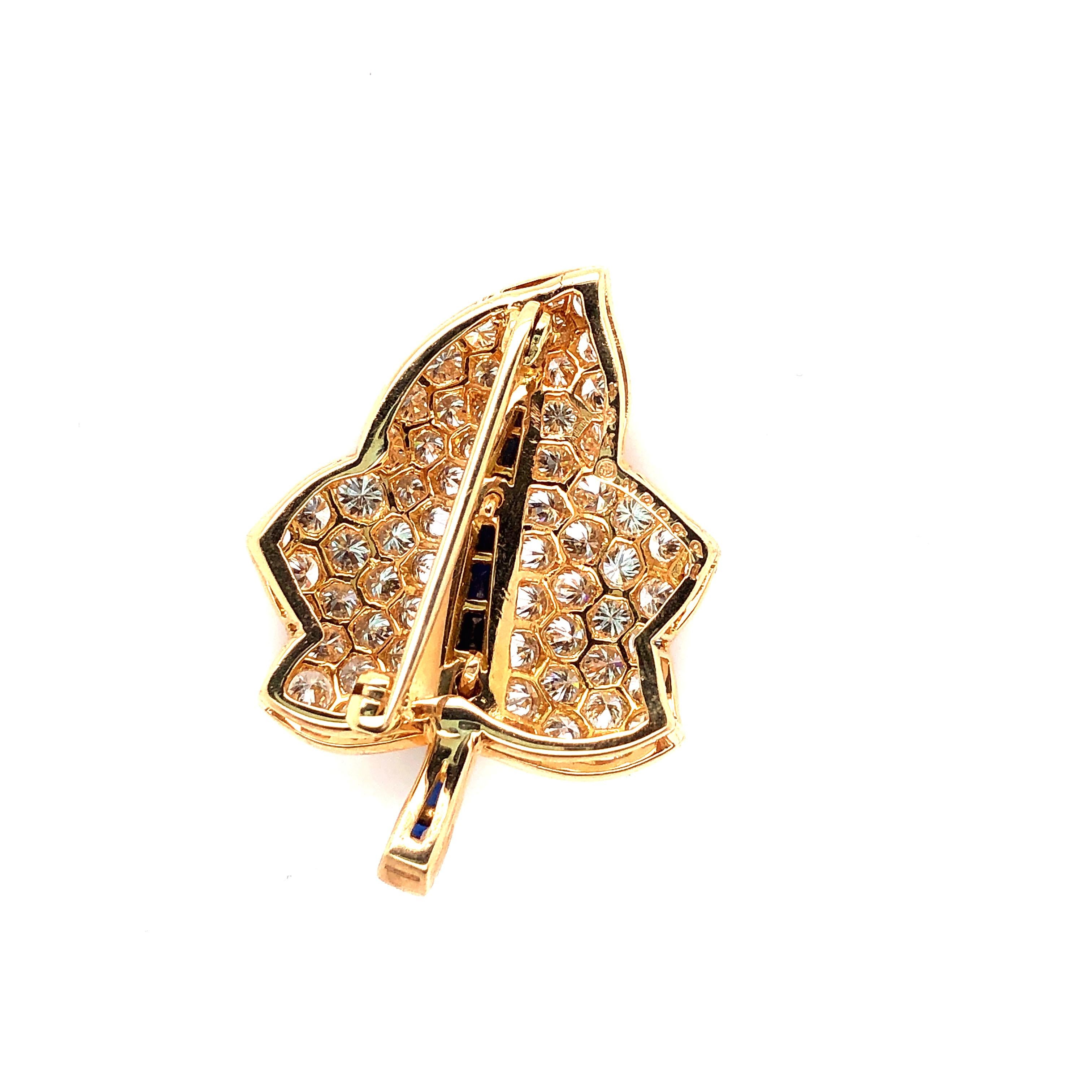 Oscar Heyman 18kt yellow gold maple leaf brooch contains 66 round diamonds weighing 3.23cts (F-G/VS+) and 10 baguette sapphires weighing 0.66cts. It is stamped with the makers mark, 18K, and serial number 200992.

Brooch measures 34mm in length by