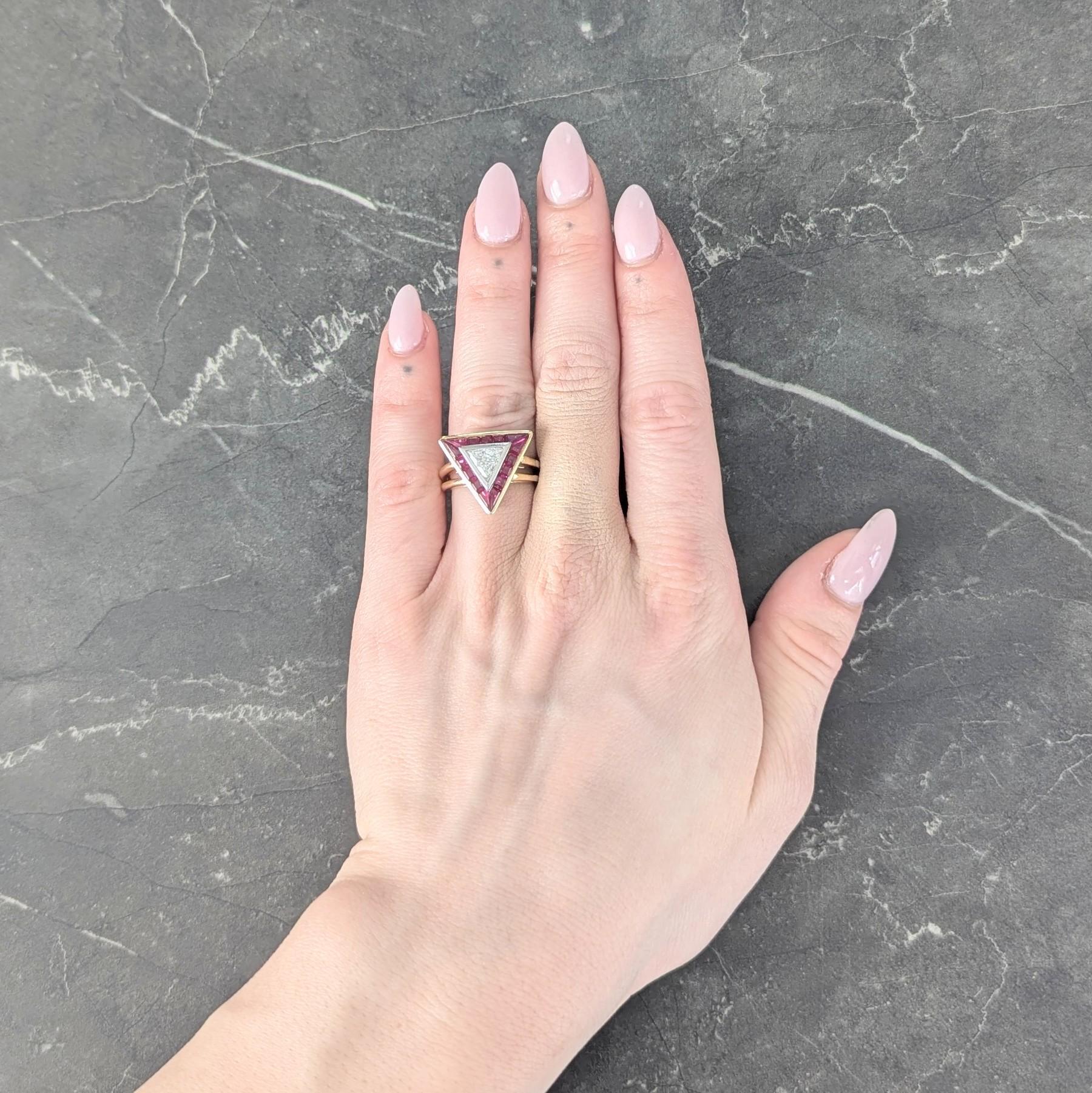 Centering a trilliant cut diamond weighing approximately 0.60 carat - G color with VS2 clarity
Bezel set in platinum with a recessed halo surround of square and kite cut rubies
Weighing approximately 1.50 carats total - transparent medium purplish