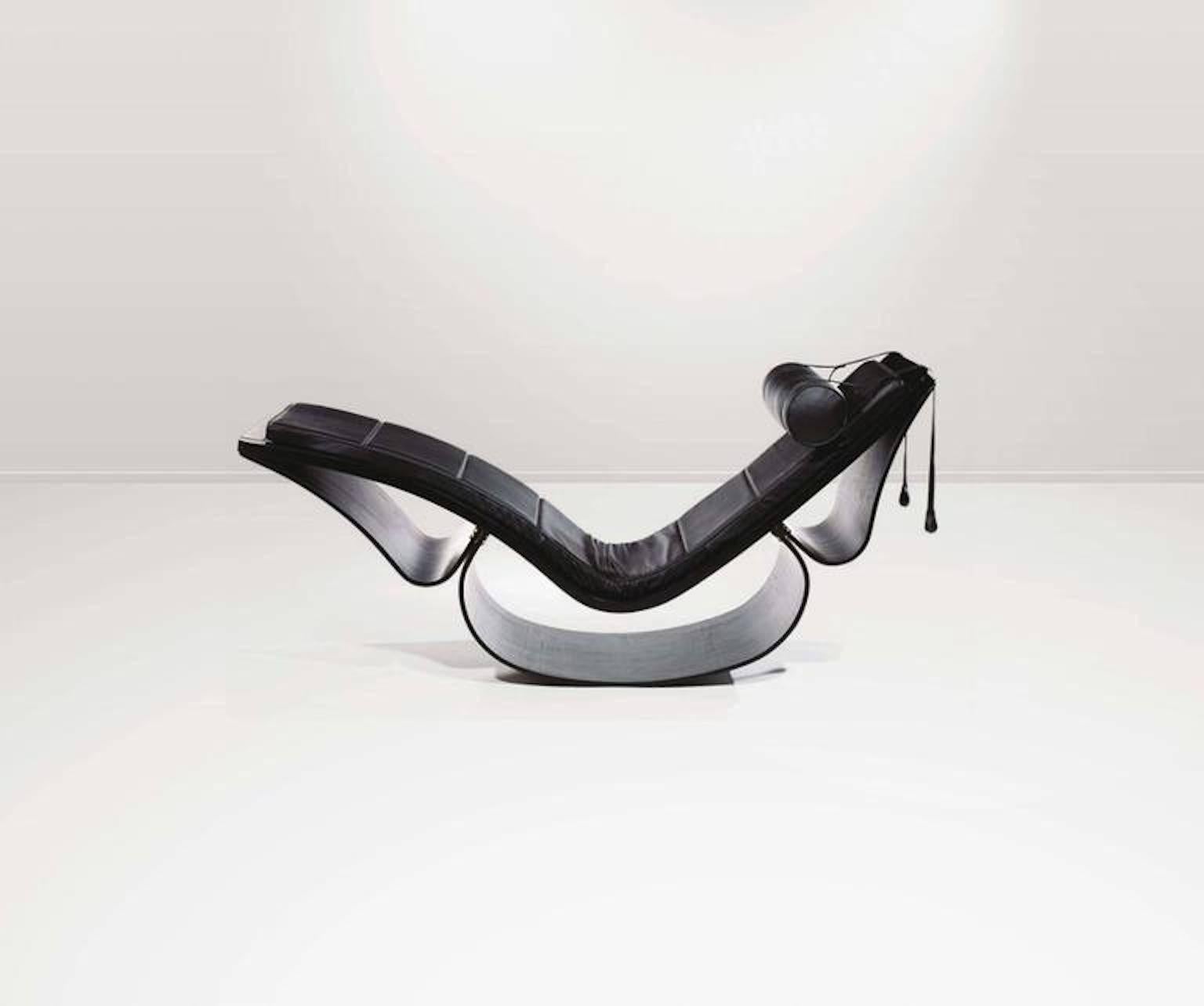 Chaise longue sculpturale à bascule Rio, conçue en 1978, édition contemporaine. Piètement composé de trois éléments dont des rubans souples de stratifié de frêne foncé moulé, coussins maintenus par des sangles sur l'assise et le dossier, appui-tête