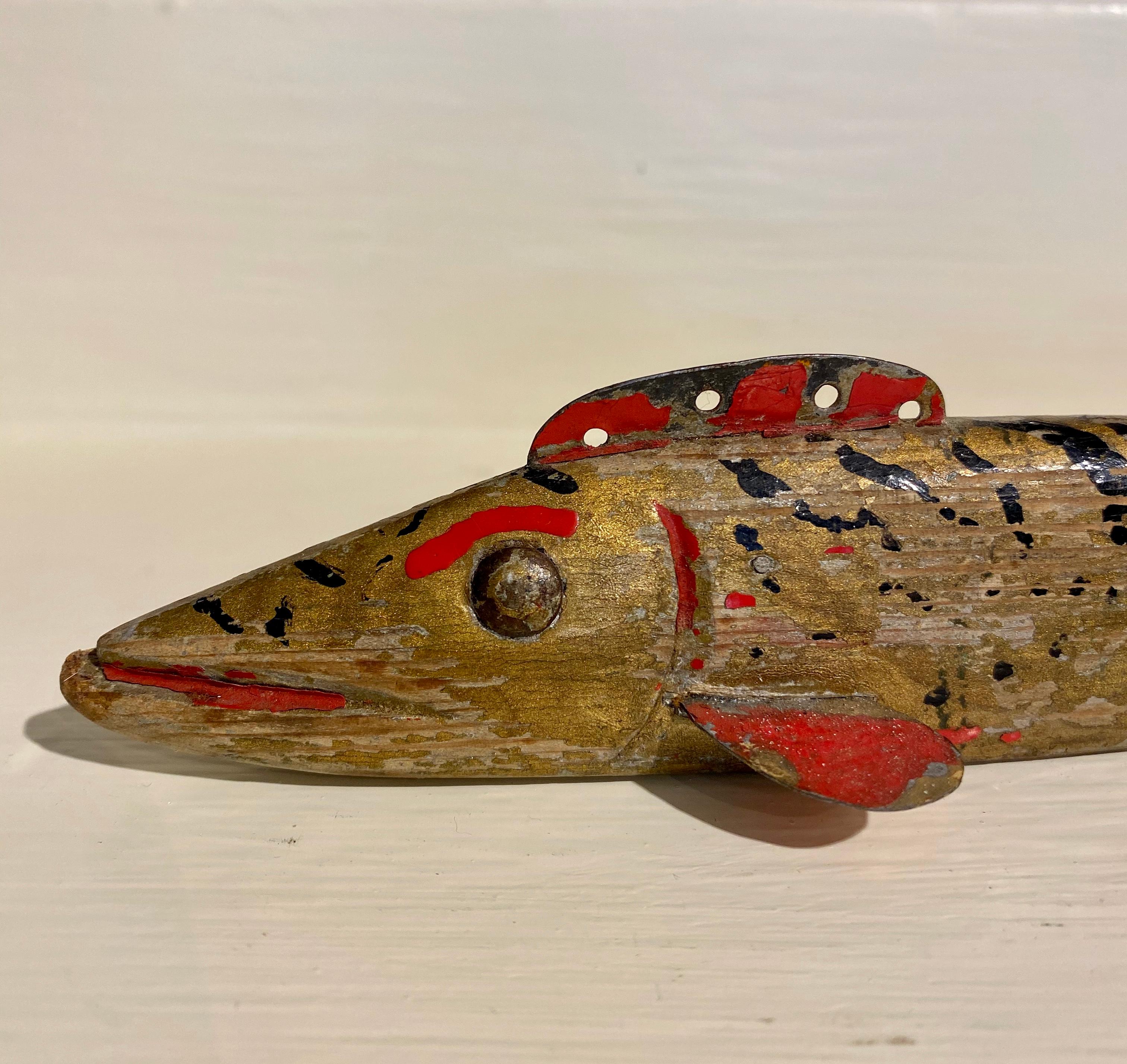 Oscar Peterson Brook Trout Decoy, Cadillac, Michigan, circa 1920s, an early Period II Peterson working ice fishing decoy painted in a Classic brook trout pattern with black and red squiggles and dots on a gold body, with red gills and mouth. The