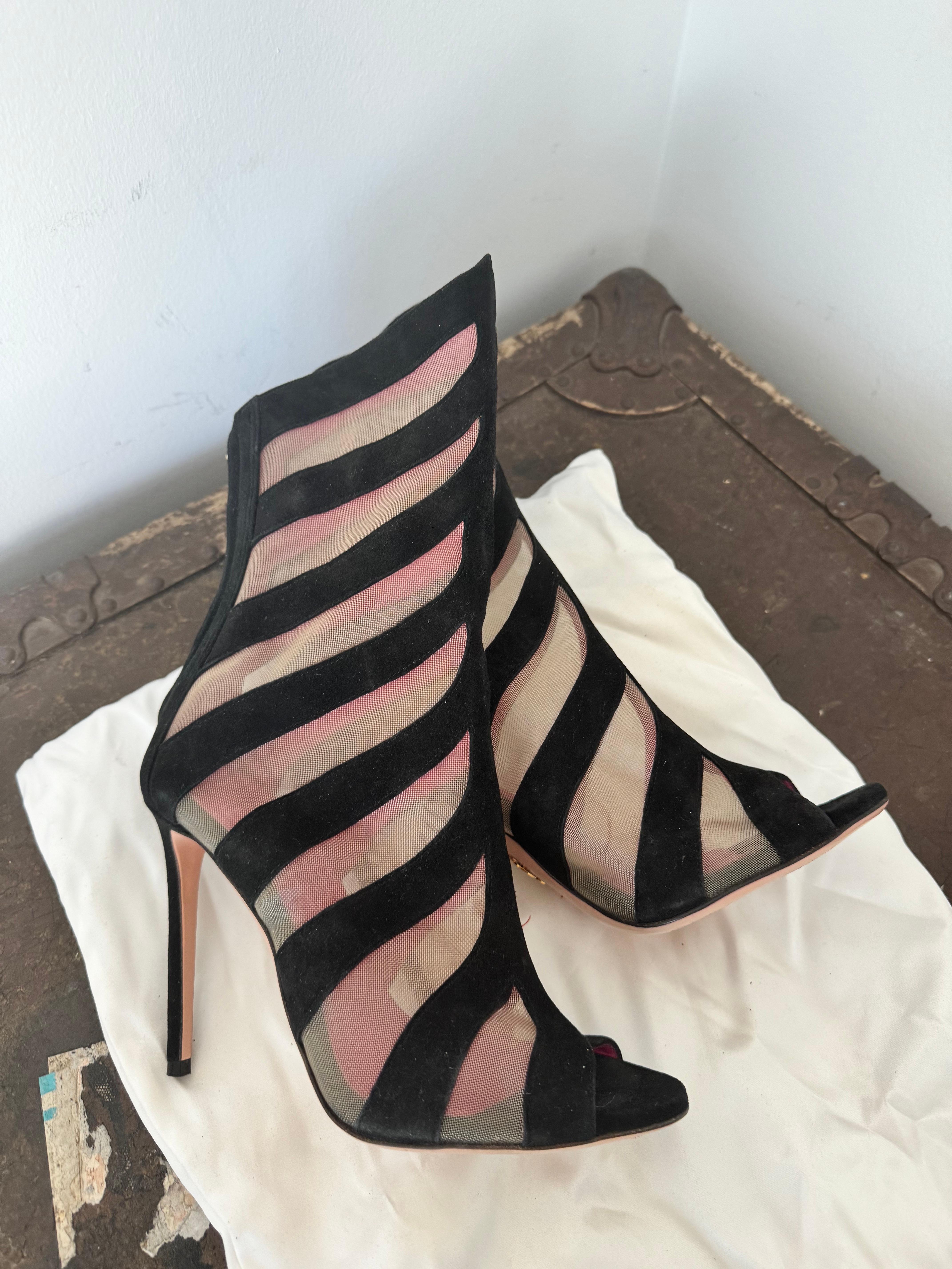 material offers a lightweight and breathable feel while adding a touch of transparency and allure to the shoes. The use of black suede strips adds a luxurious and elegant contrast against the mesh.
Open Toe Design:
The open toe style introduces a