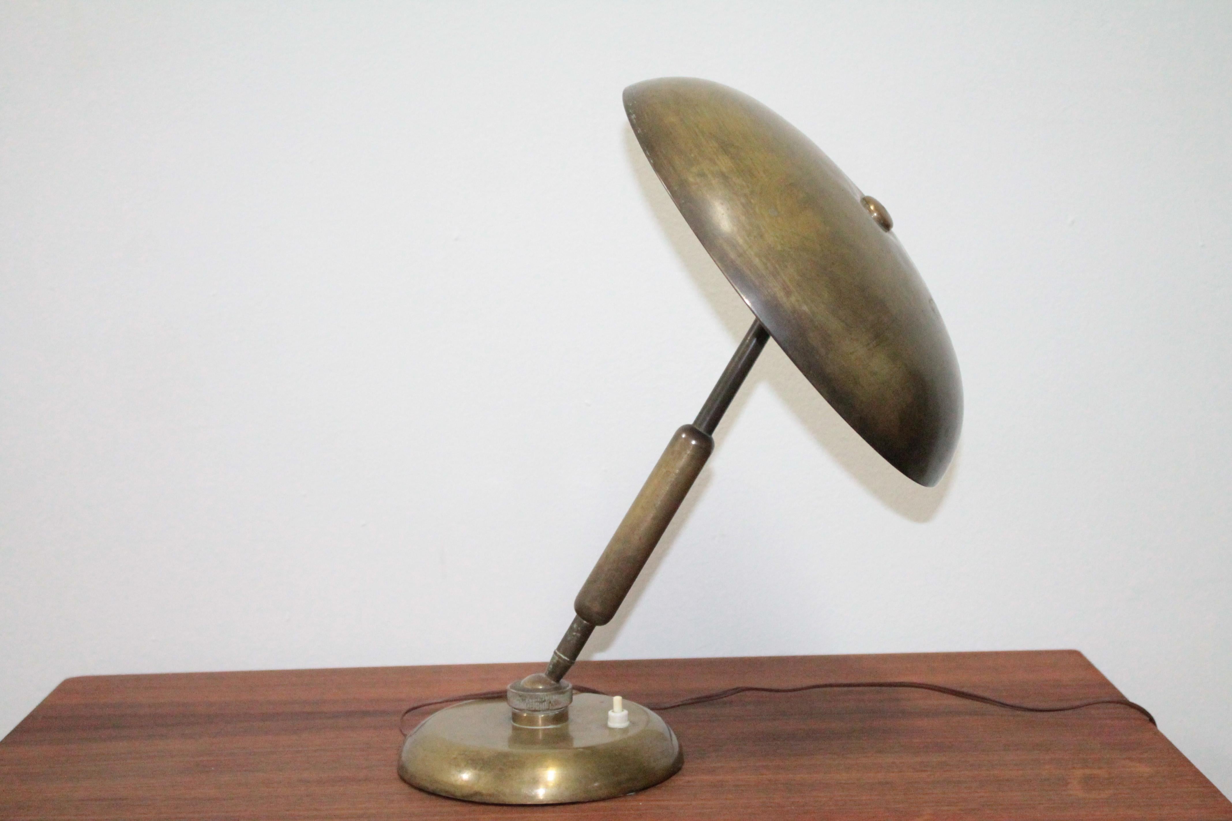 Beautiful 1950s table lamp designed by Oscar Torlasco for Lumi Milano, completely in brass with two lights, articulated at the base and at the top, original patina.