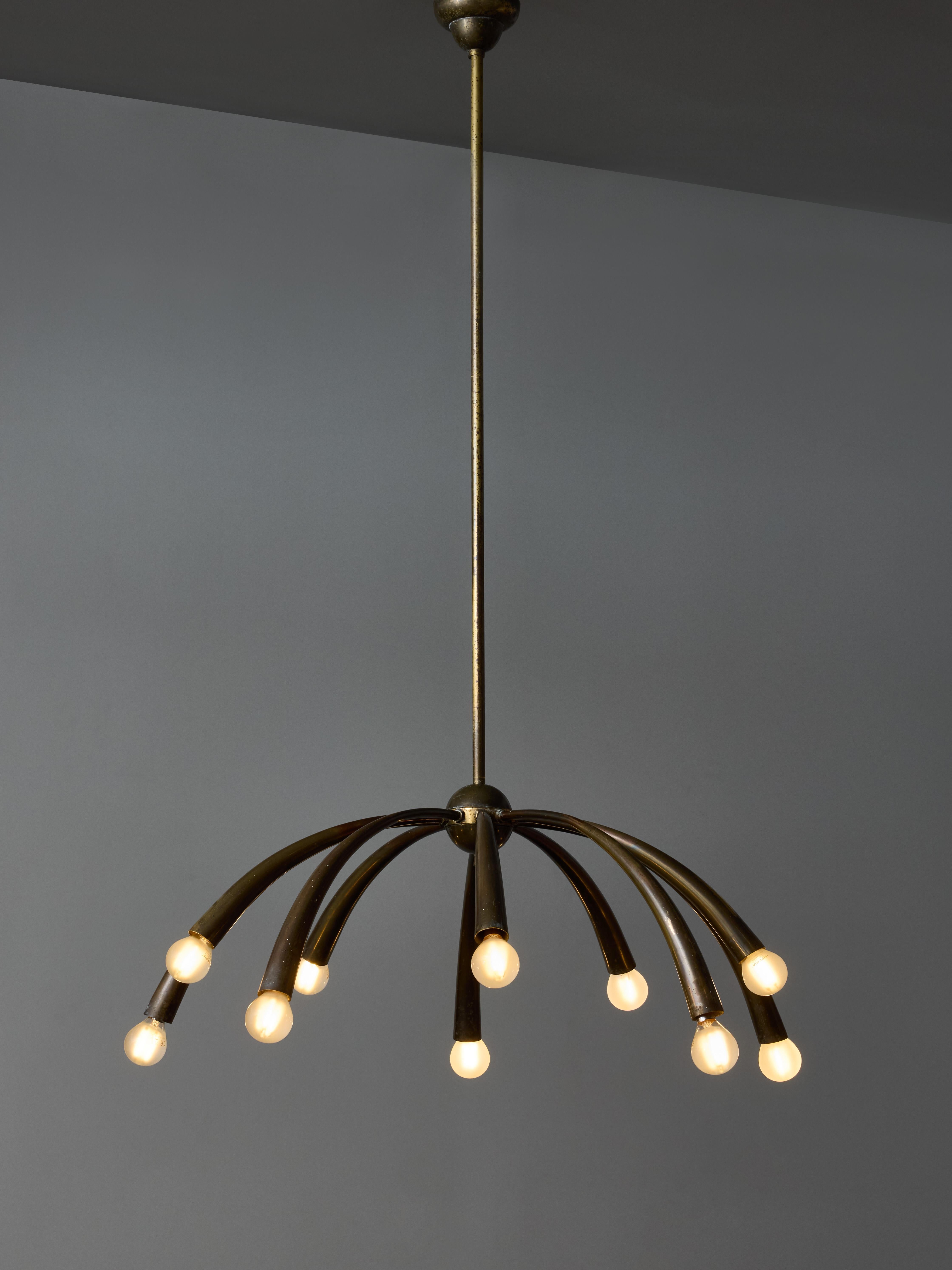 Mid century chandelier designed by Oscar Torlasco for Lumi, all made in patinated brass.
It is made of ten arms of light, tapered cones pointing downward with alternating height.

Vintage condition

Oscar Torlasco (1934-2004)

Oscar Torlasco is an
