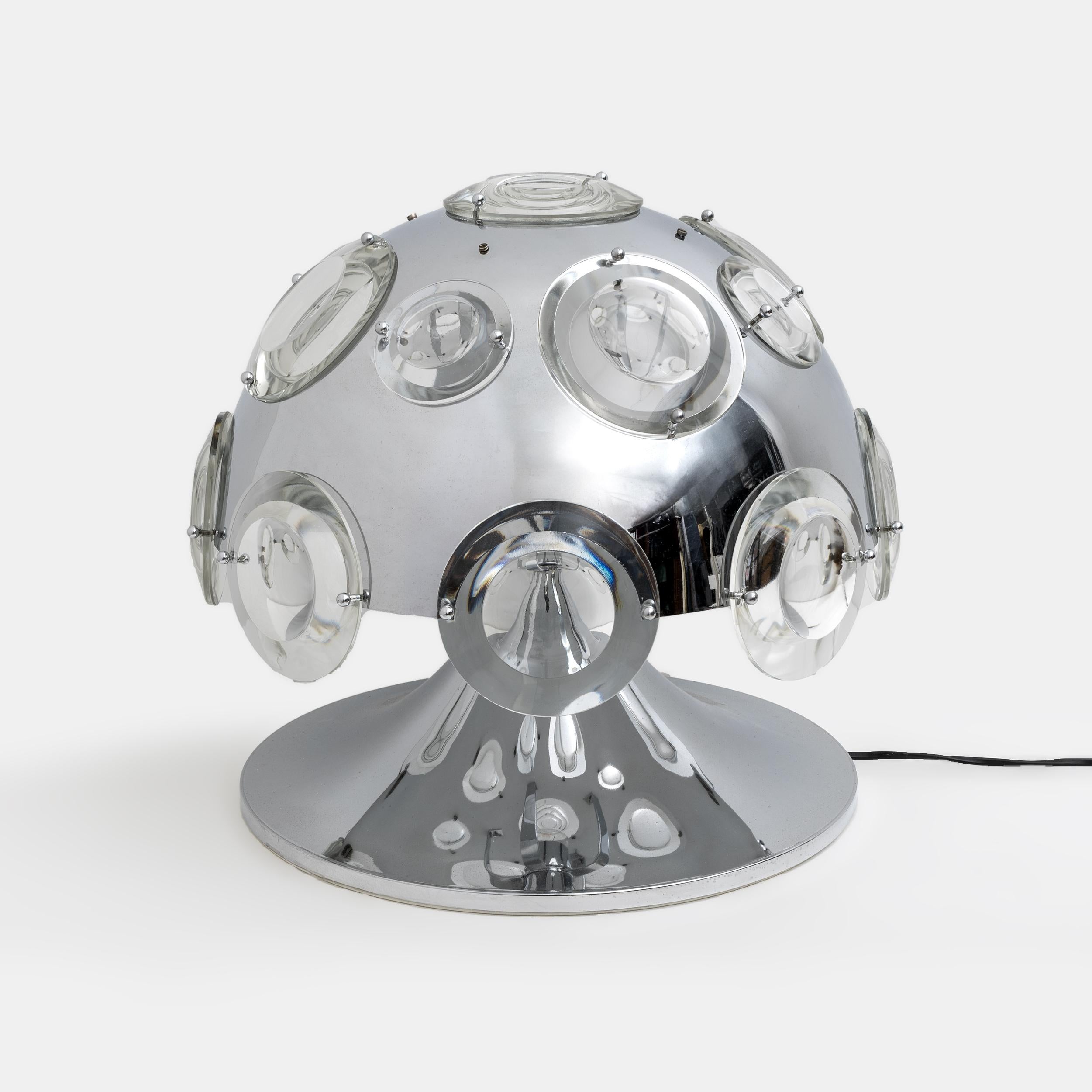 Preciosa y rarísima lámpara de mesa de la Era Espacial diseñada por Oscar Torlasco para Stikronen en los años 70. Fabricado en Italia.

La lámpara es de metal cromado con base de tulipa y difusor decorado con elementos de cristal con efecto de